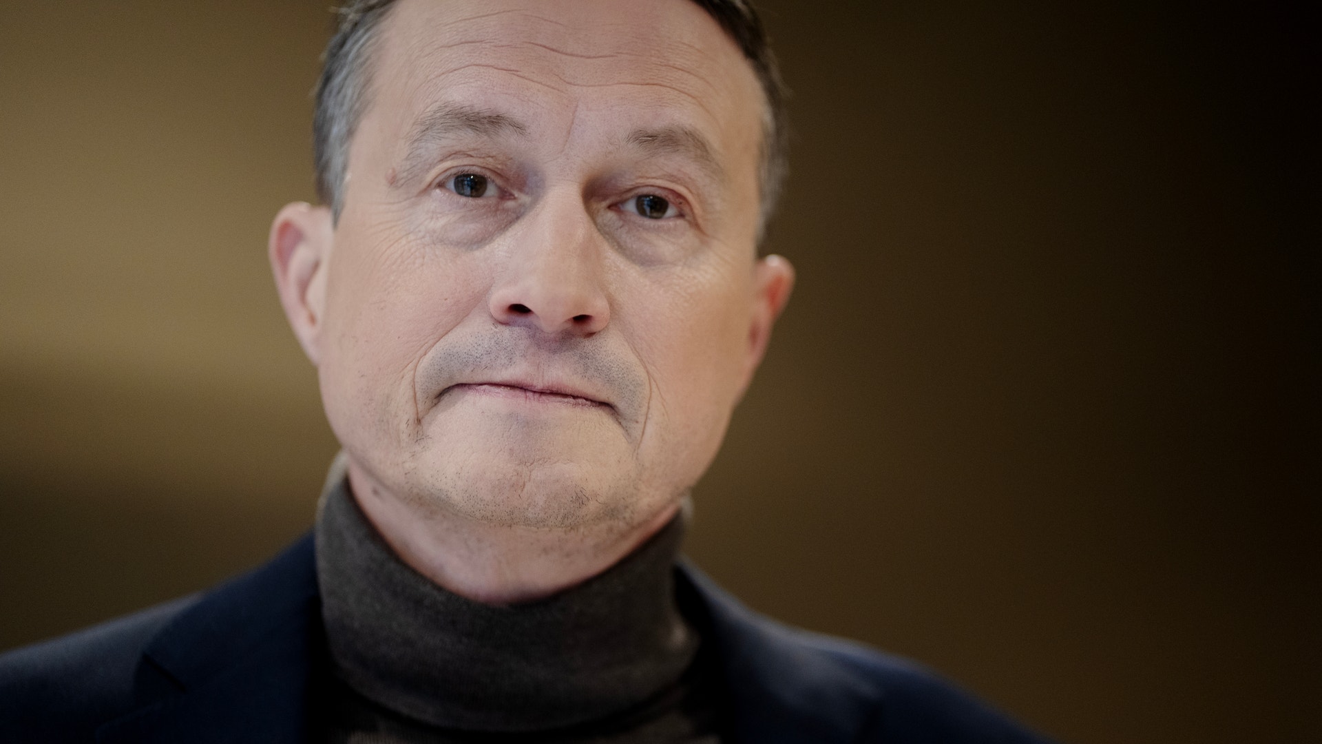 Porträtt av en man med grått hår och mörk tröja