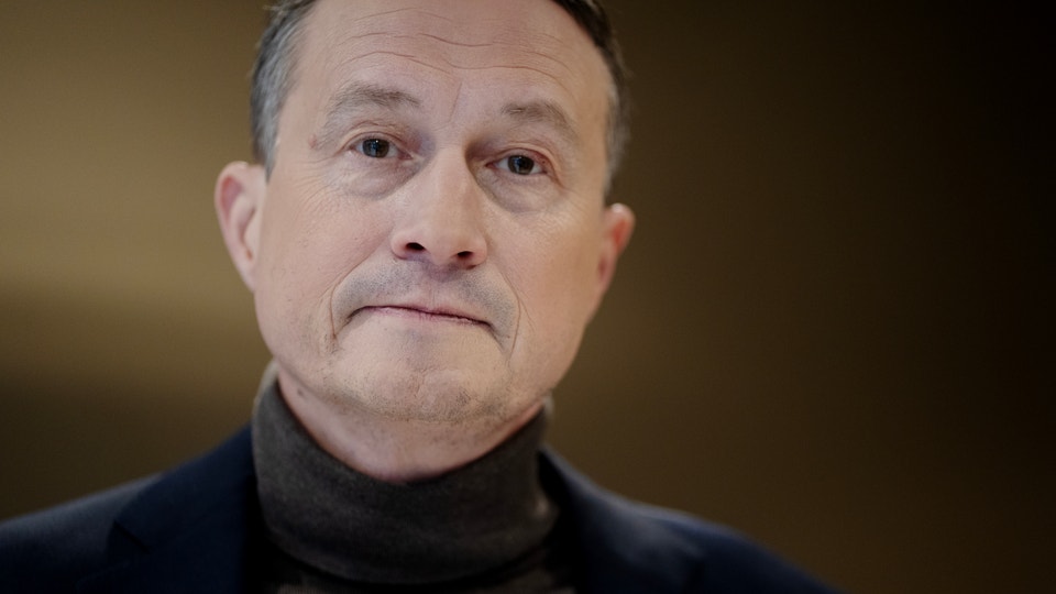 Porträtt av en man med grått hår och mörk tröja