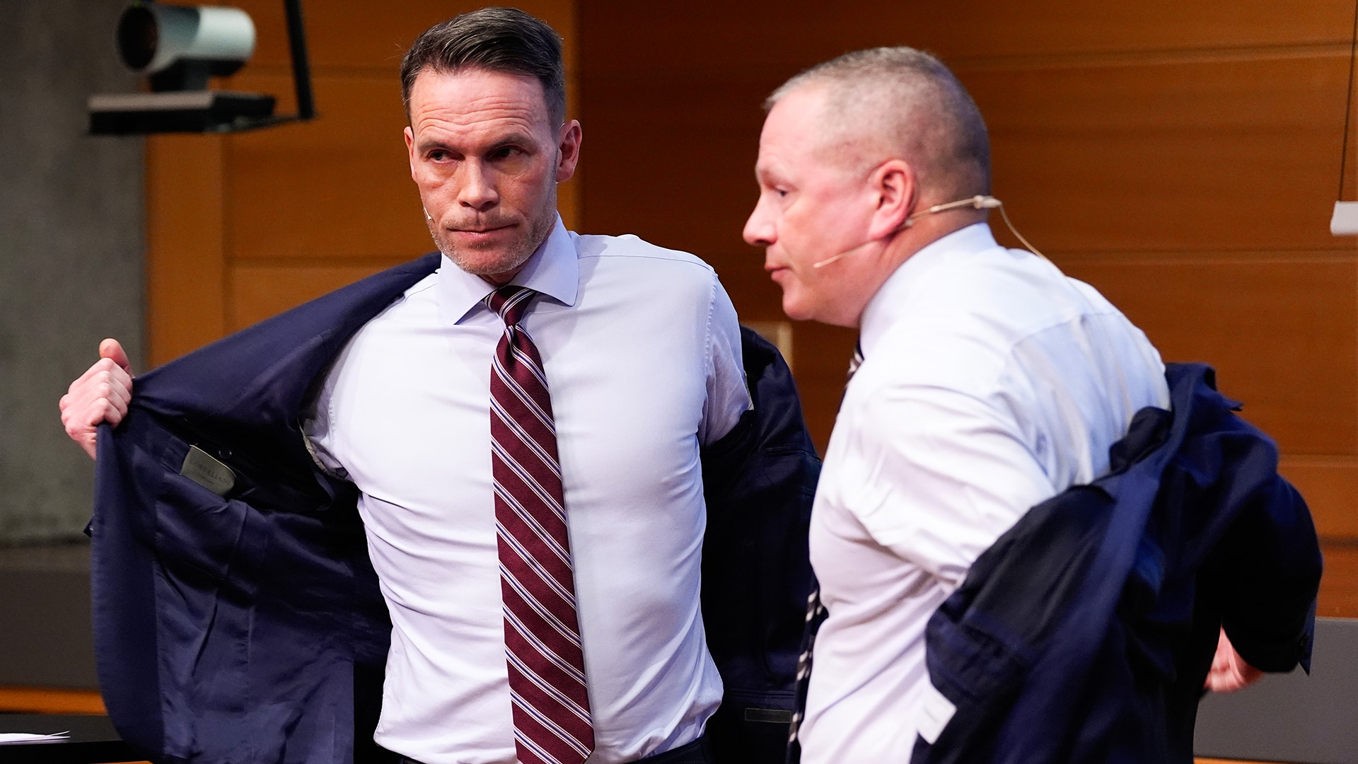 Två män i affärskläder diskuterar tillsammans i en kontorsmiljö.