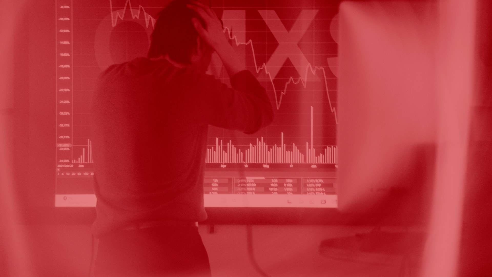 Person som analyserar finansiella diagram och aktiekurser på en skärm