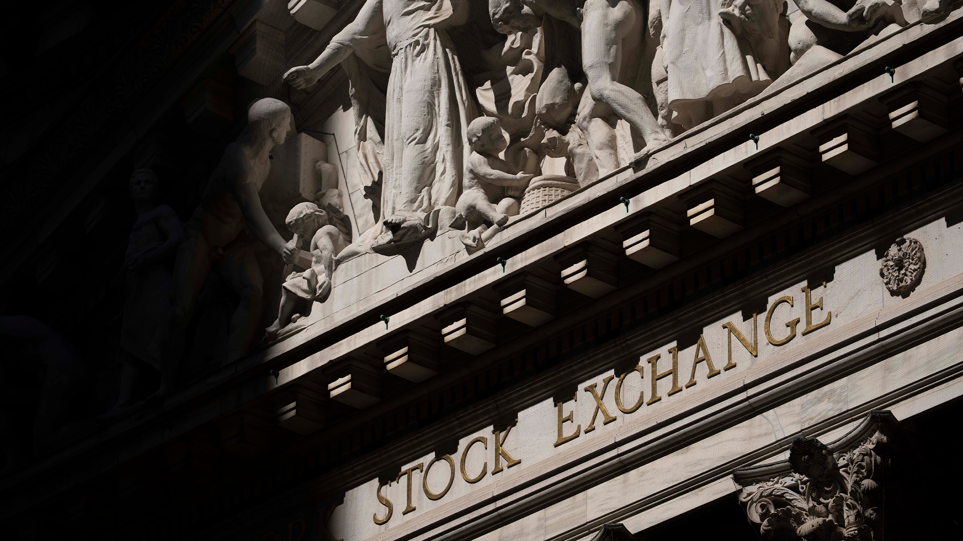Svartvit fotografi av New York Stock Exchange-bygnadens klassiska fasad med inskriptionen Stock Exchange synlig på stenen.