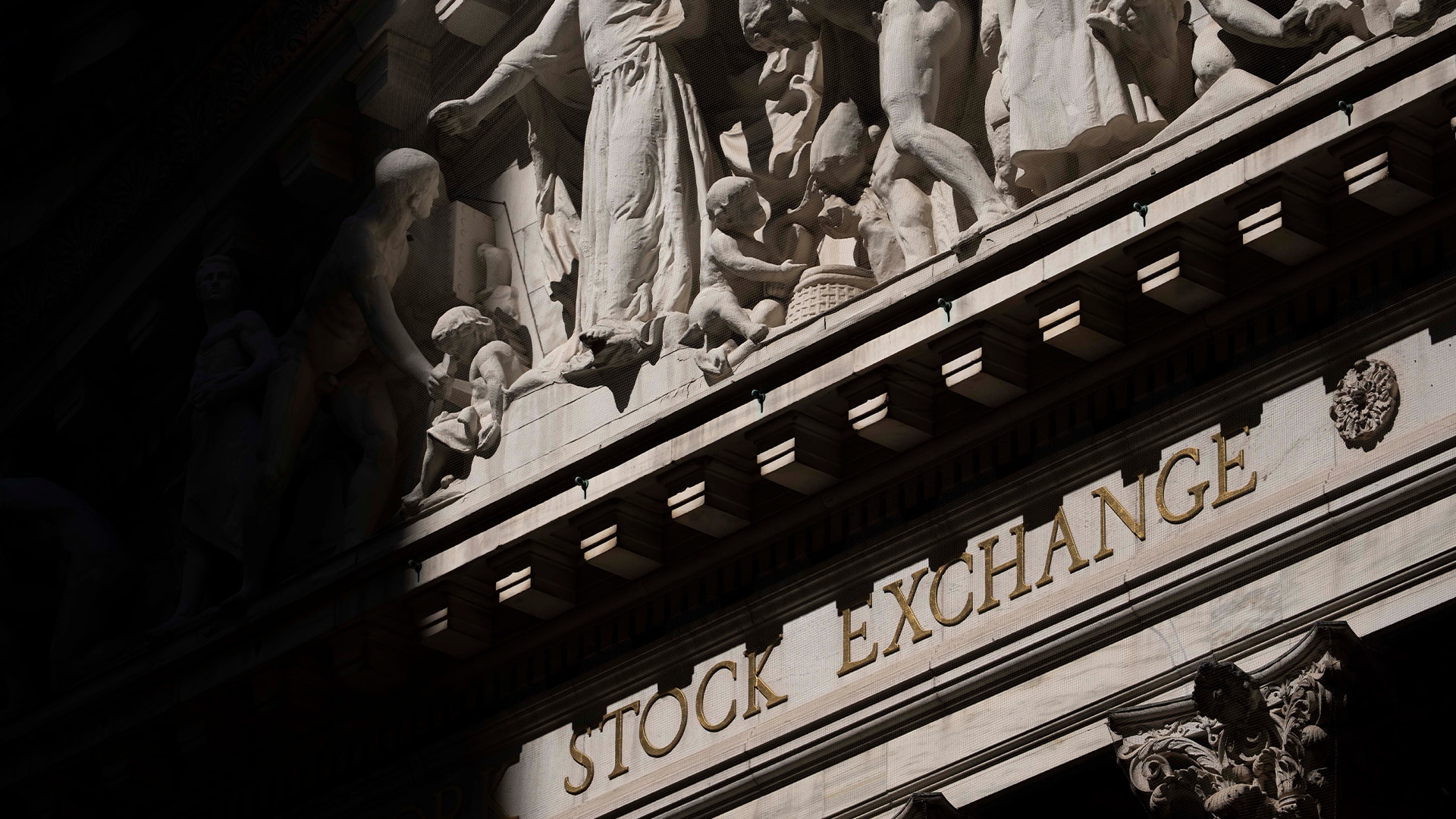 Svartvit fotografi av New York Stock Exchange-bygnadens klassiska fasad med inskriptionen Stock Exchange synlig på stenen.