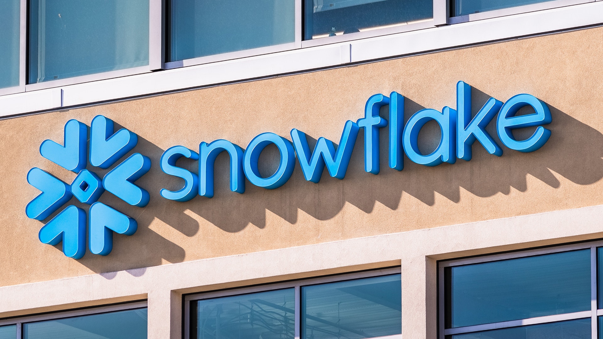 Blå skylt med Snowflake-logotypen monterad på en byggnadsfasad