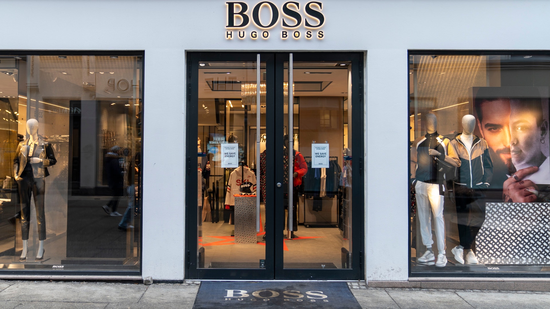 Entrén till en Hugo Boss-butik med skyltfönster där skyltdockor visar kläder.