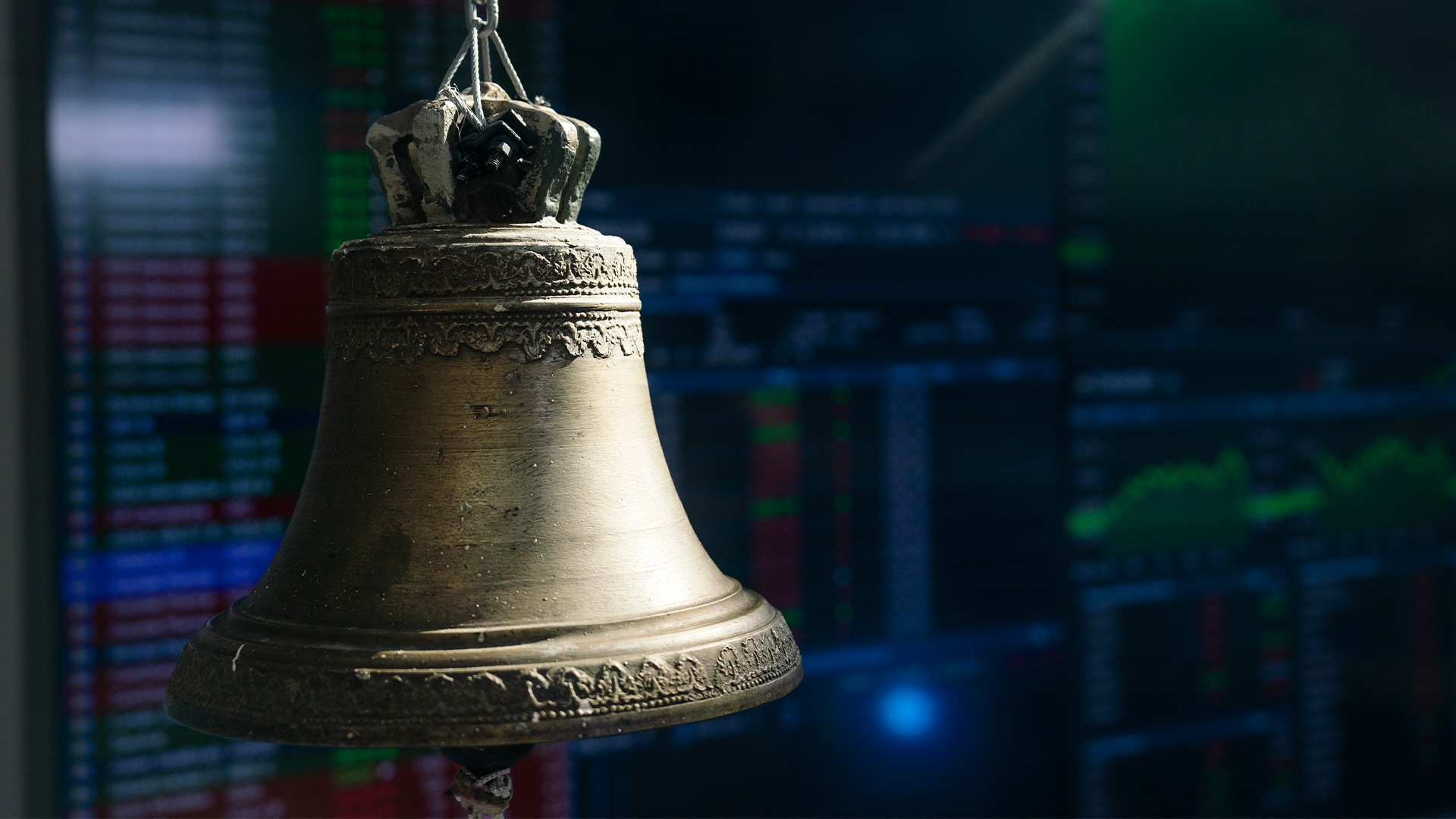 En klassisk börsklocka framför en suddig börsdata-skärm