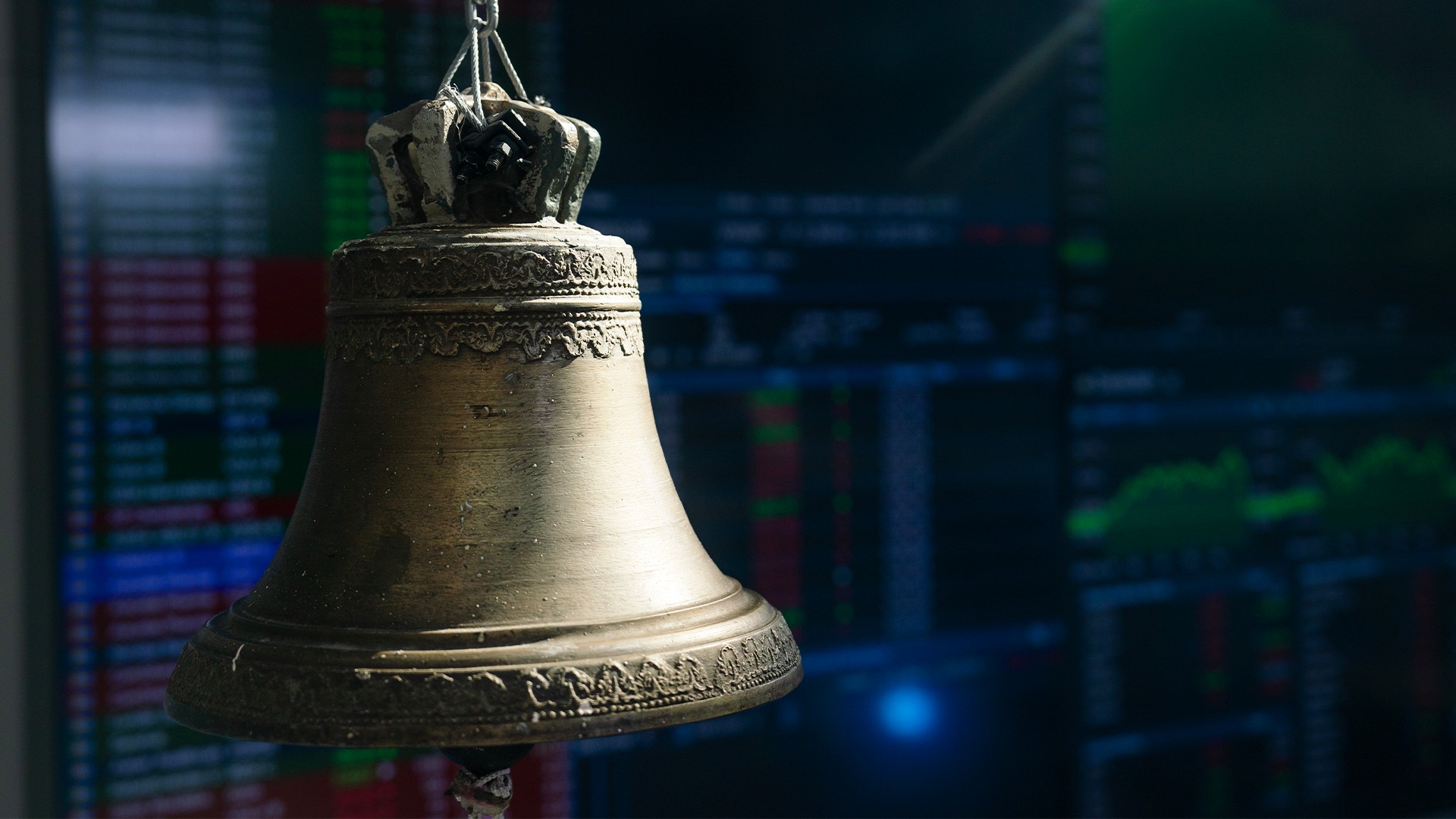 En klassisk börsklocka framför en suddig börsdata-skärm