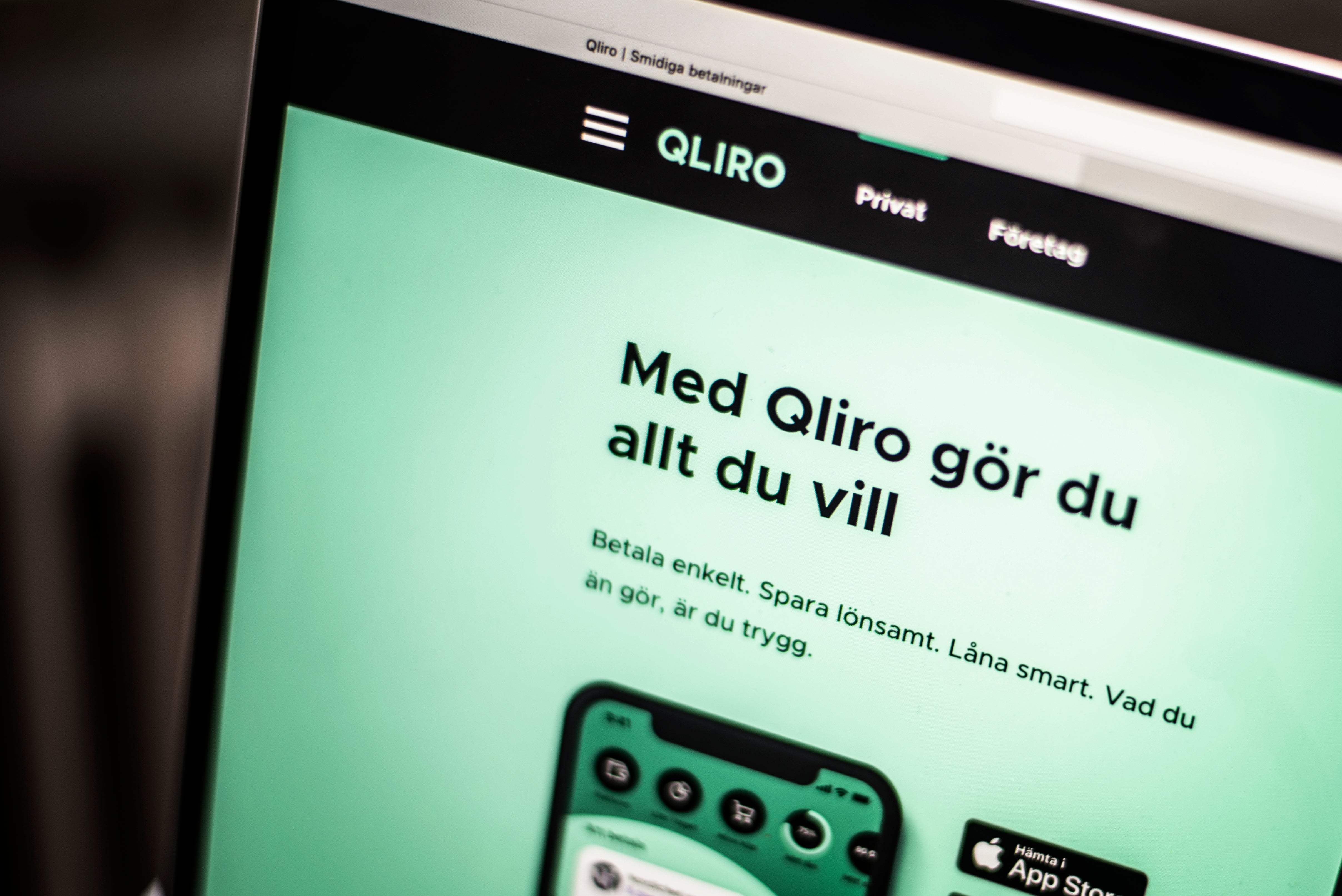 Datorskärm som visar Qliros webbplats med rubriken "Med Qliro gör du allt du vill" på en grön bakgrund.