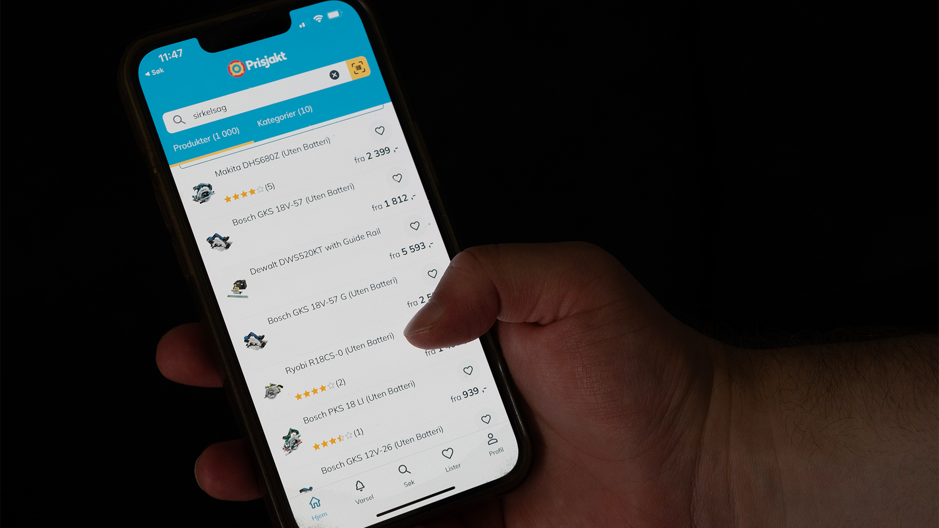Hand som håller en smartphone med Prisjakt-appen öppen, visar en lista över produkter med priser och betyg