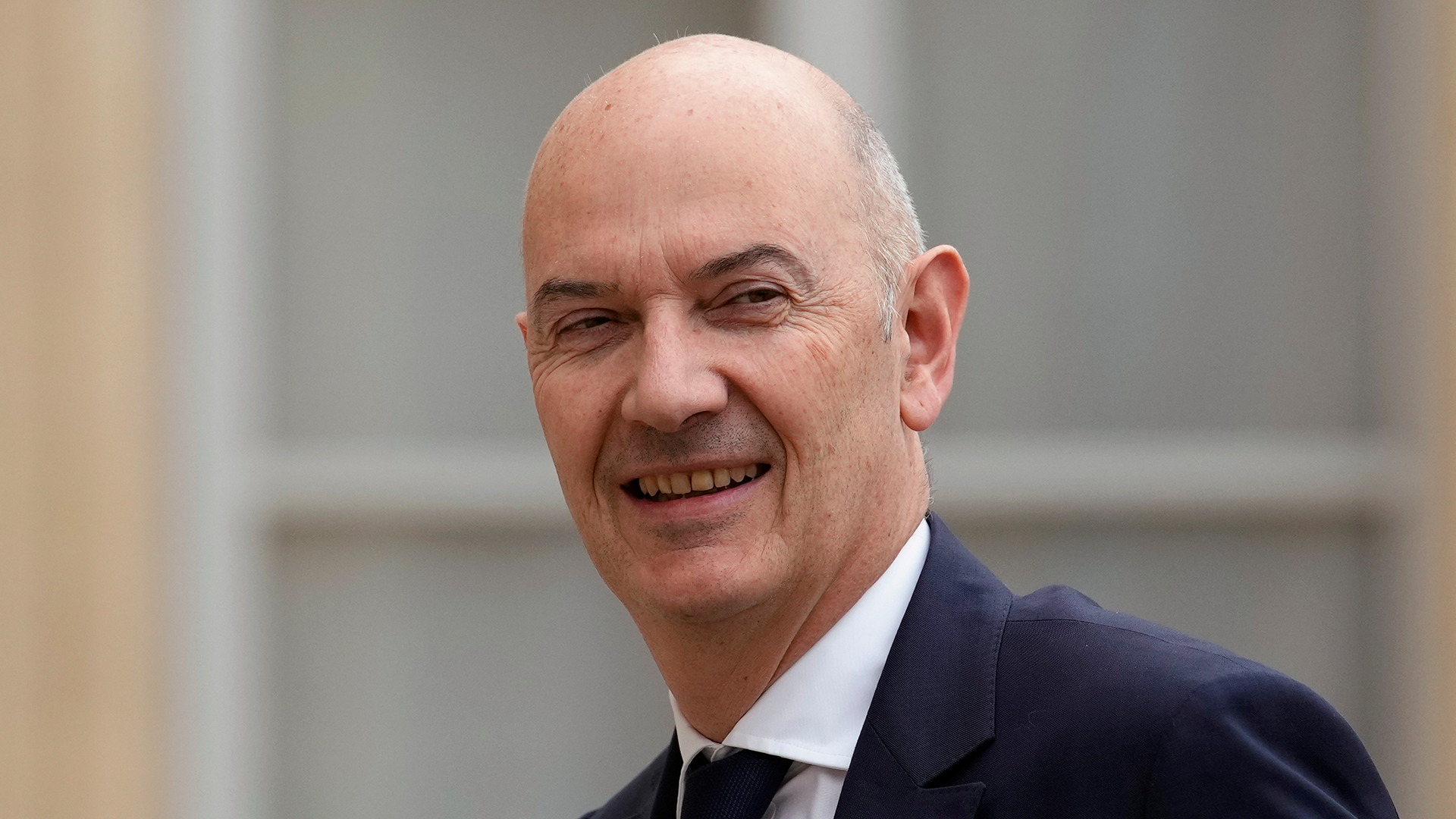 Porträttfoto av en man i mörkblå kostym och slips.