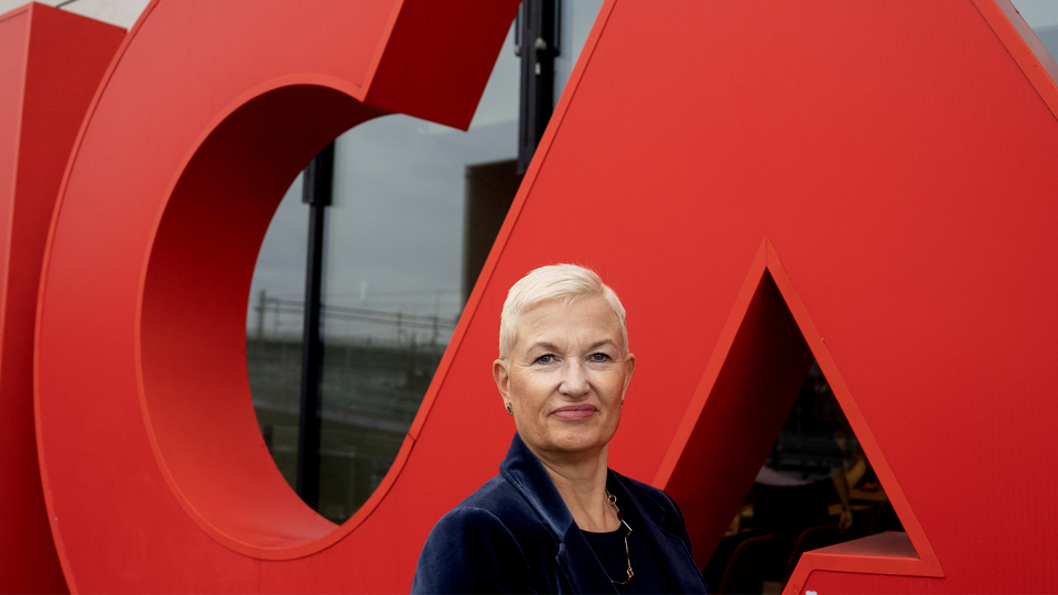 Nina Jönsson, koncernchef för Ica, står framför en stor, röd Ica staty.