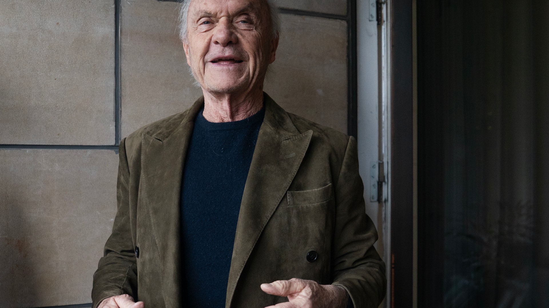 Porträtt av en äldre man i olivfärgad kavaj och mörkblå skjorta