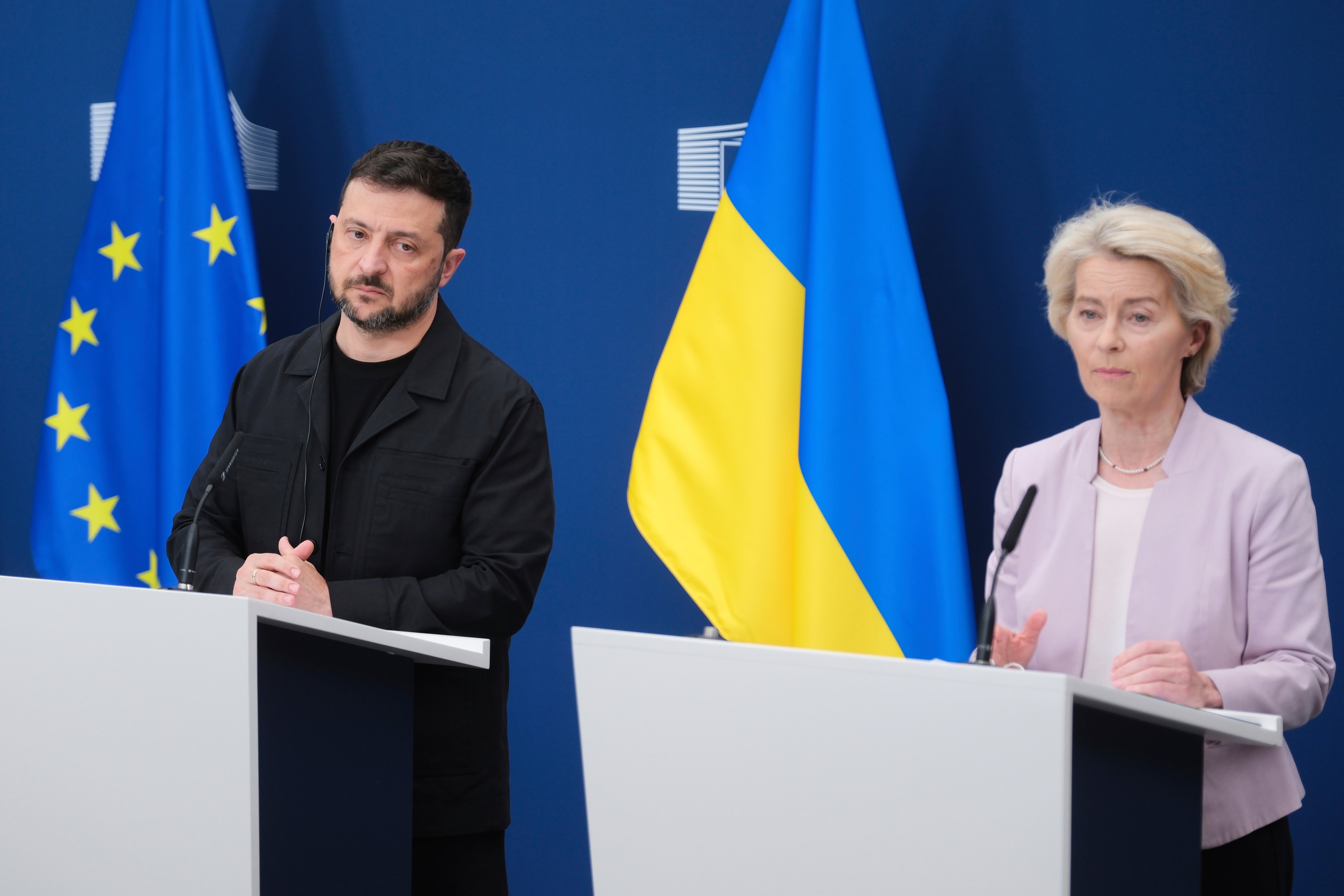 En man och en kvinna står vid varsin talarstol framför EU:s och Ukrainas flaggor under en pressträff.
