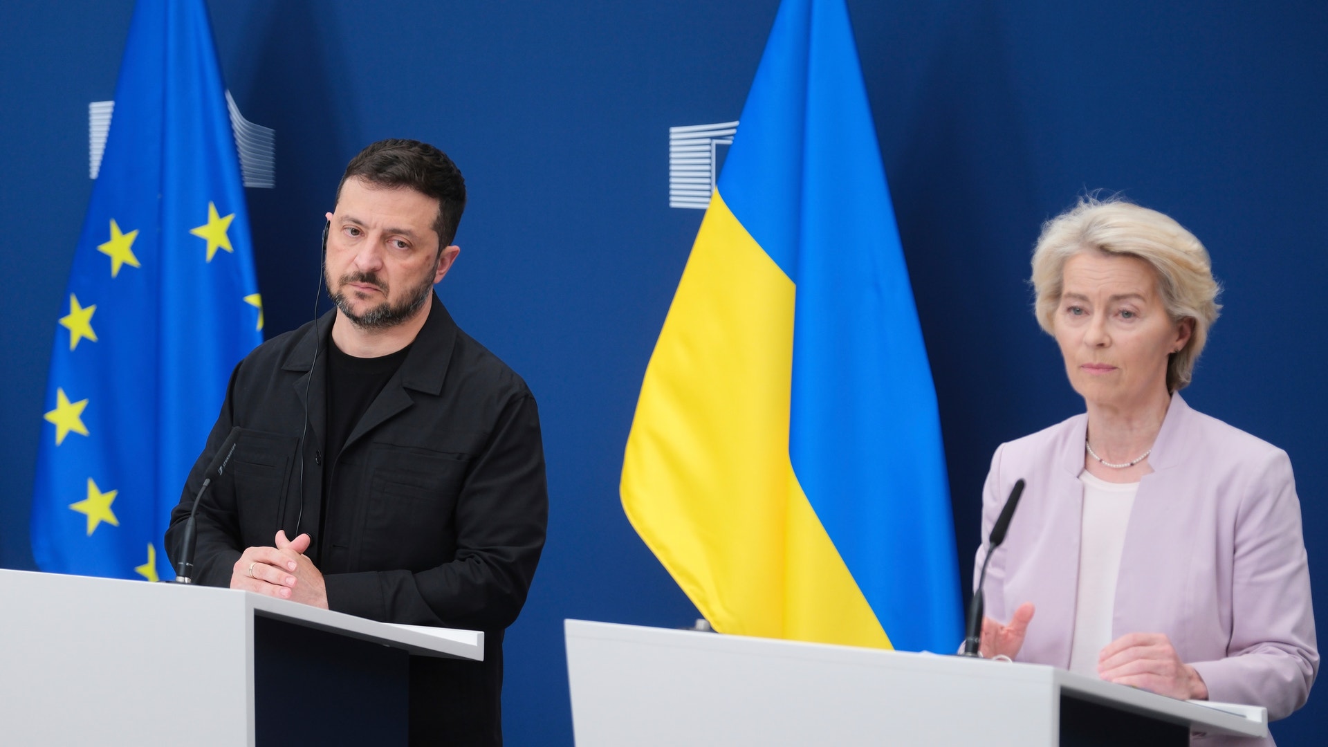 En man och en kvinna står vid varsin talarstol framför EU:s och Ukrainas flaggor under en pressträff.