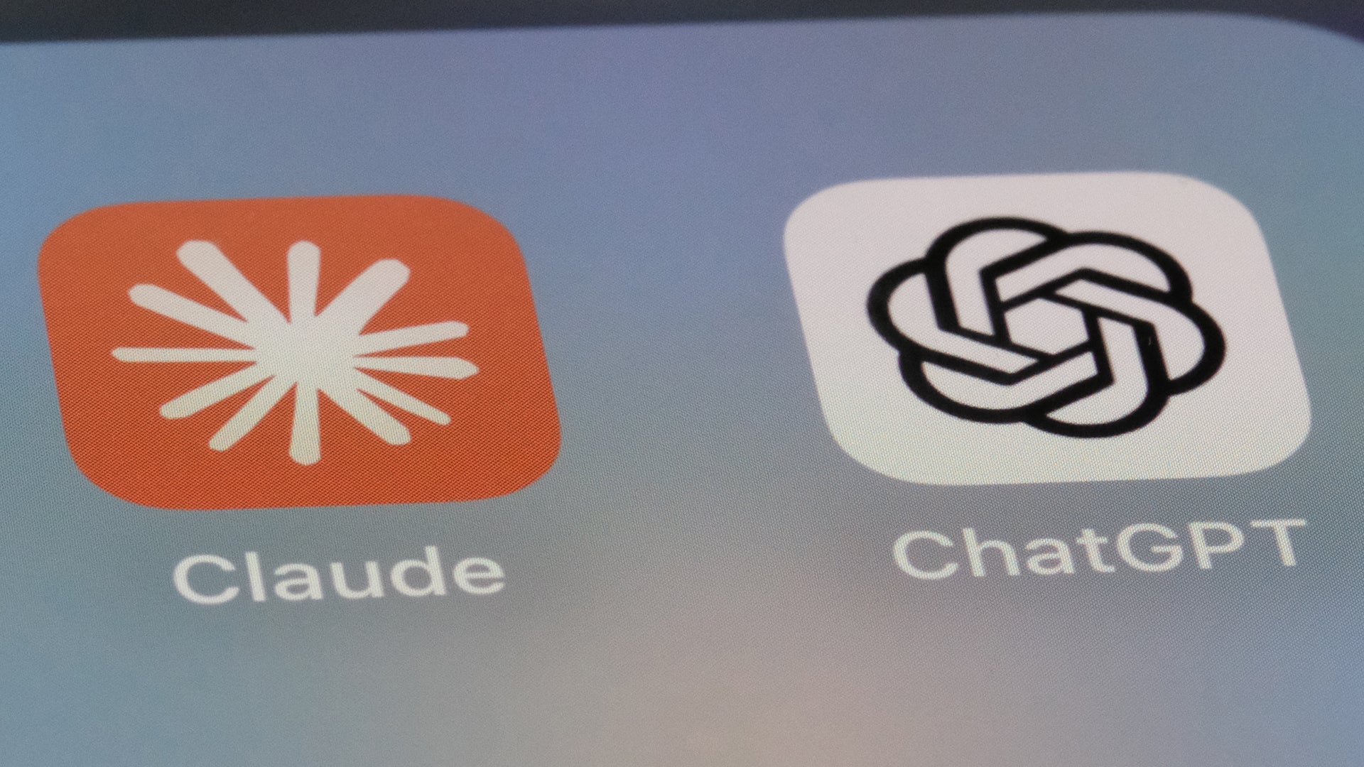 Två AI-applikationsikoner bredvid varandra: Claude med orange bakgrund och ChatGPT med vit bakgrund.