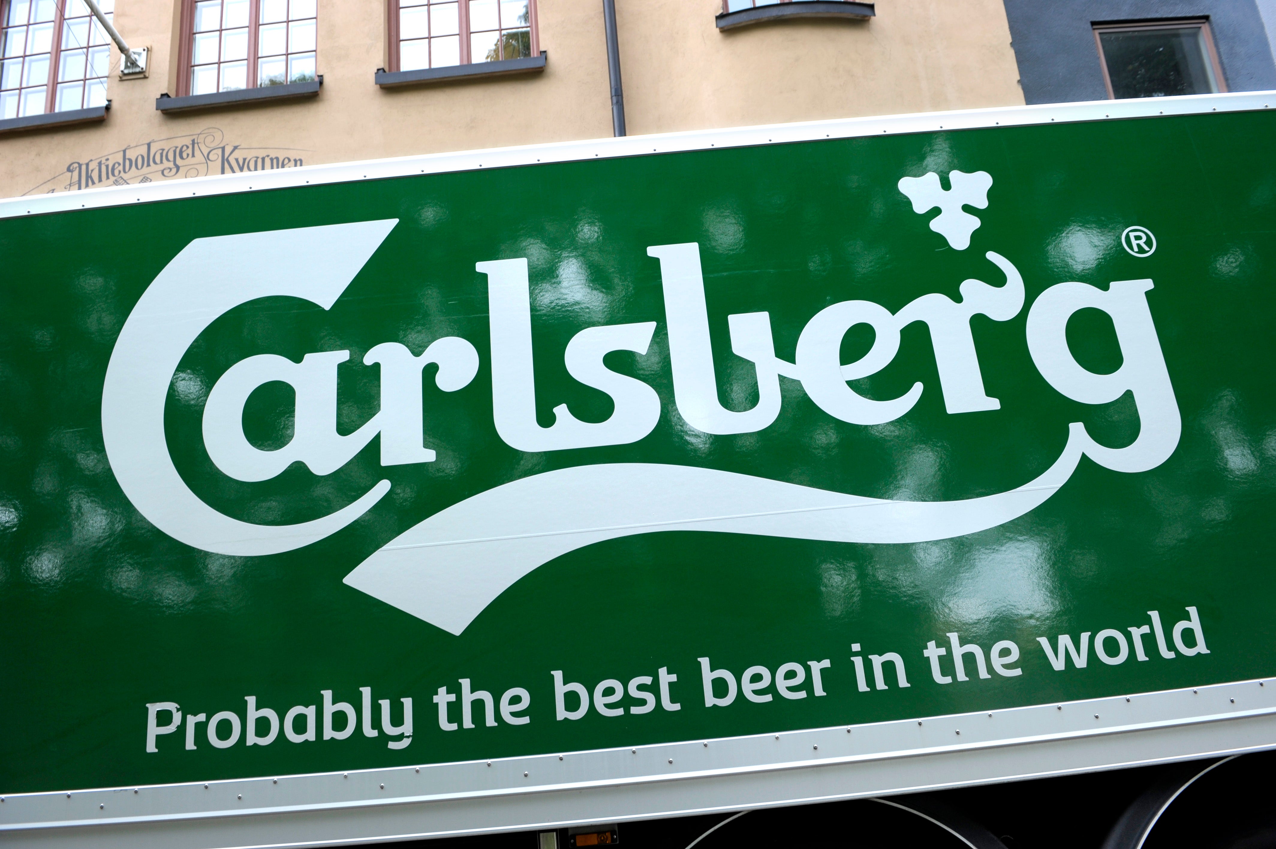 Carlsberg-logotyp på grön reklamskyllt med texten 'Probably the best beer in the world'