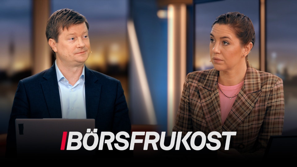 Två personer i studiomiljö med stadsutsikt i bakgrunden.