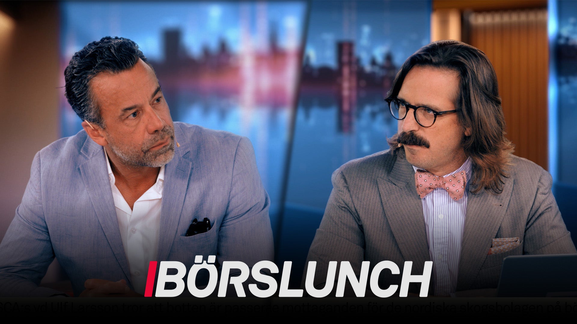 Två män i affärskläder sitter och diskuterar i en TV-studio med stadshorisont i bakgrunden. Texten Börslunch visas längst ned på skärmen.