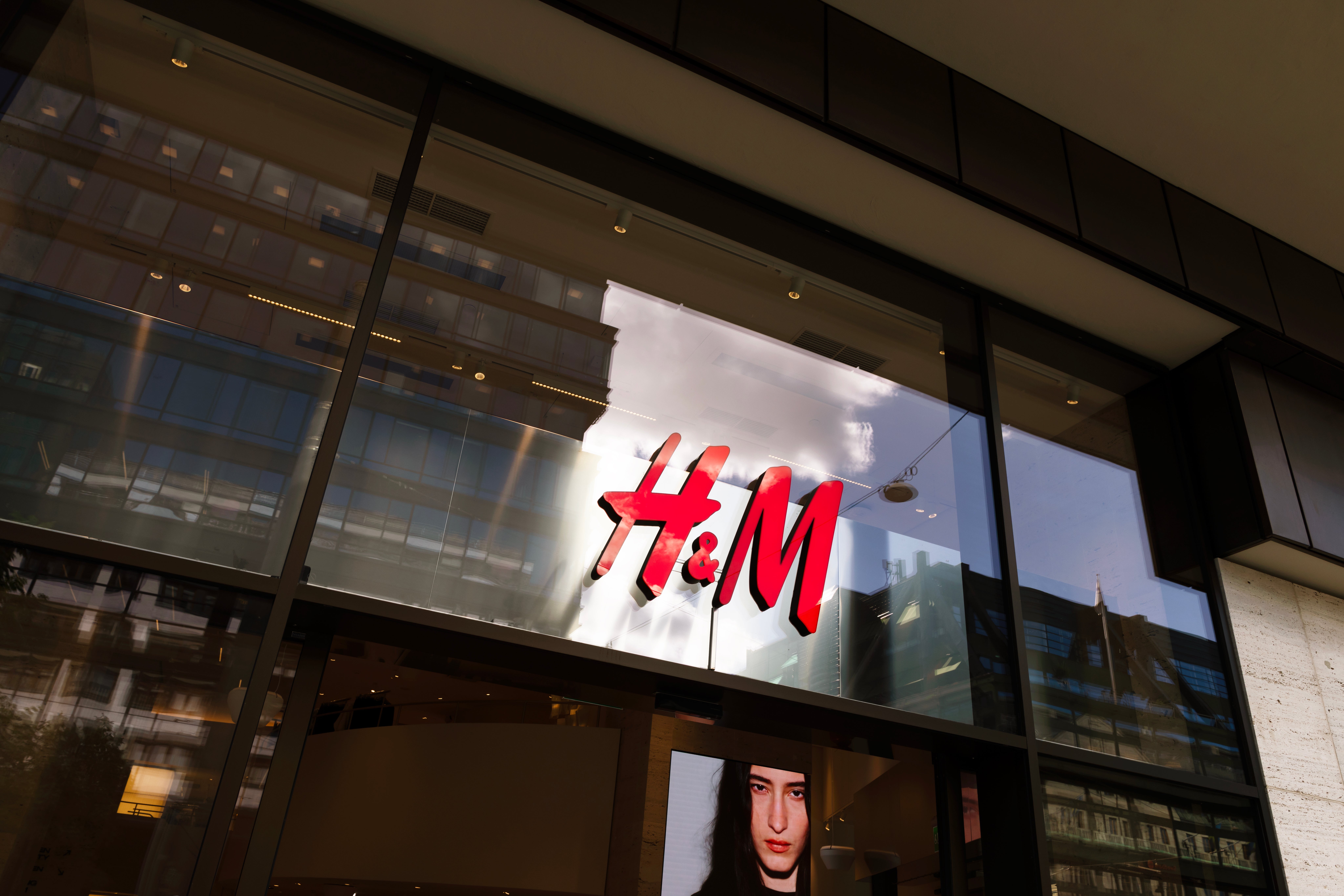 H&M-butikens fasad med röd logotyp på upplyst skylt