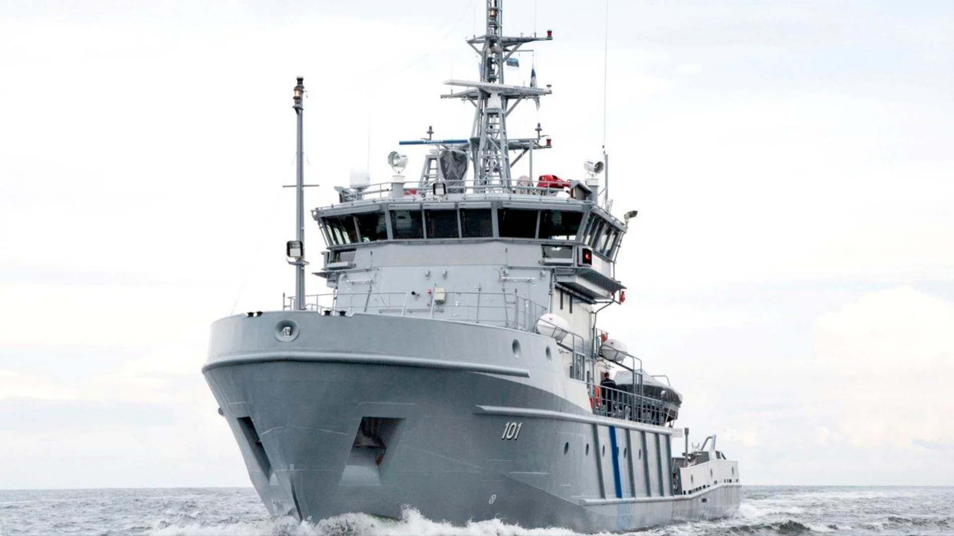 Gråmålat marinfartyg på öppet hav sett från fronten, utrustat med torn, antenner och olika militär utrustning.