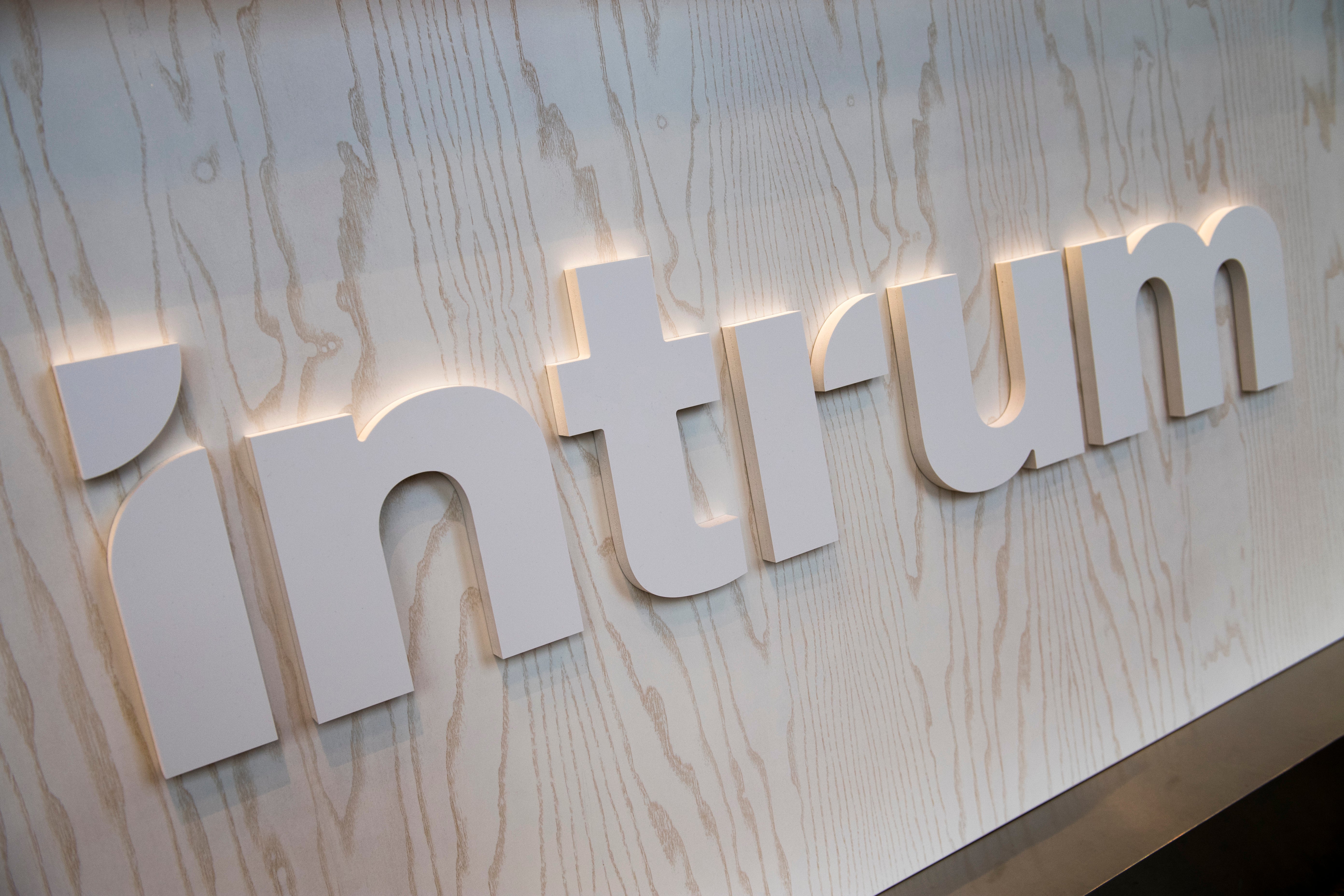 Upplysta vita bokstäver som bildar ordet "Objectic" på en ljus trävägg med bakgrundsbelysning