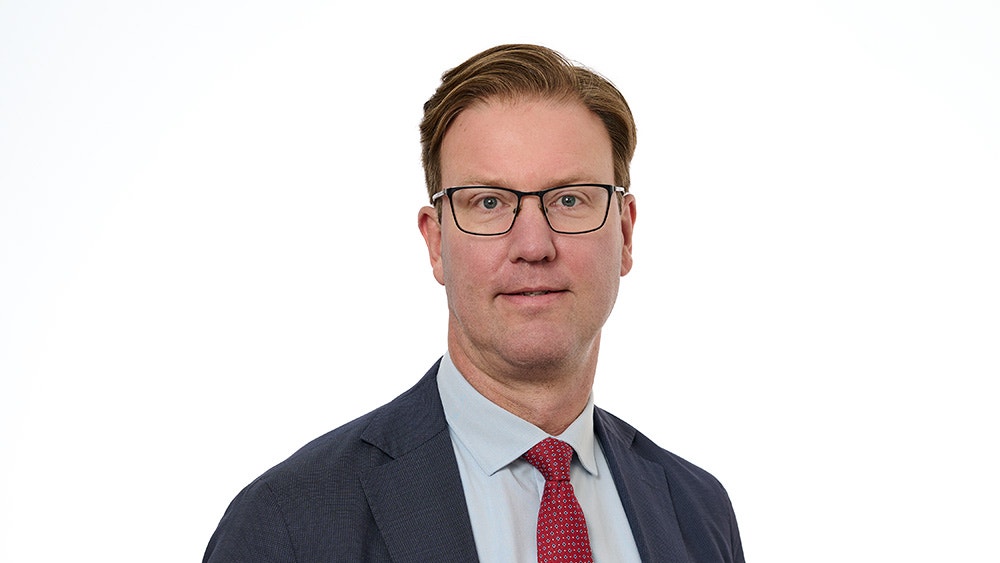 Porträtt av en man i affärskläder mot vit bakgrund