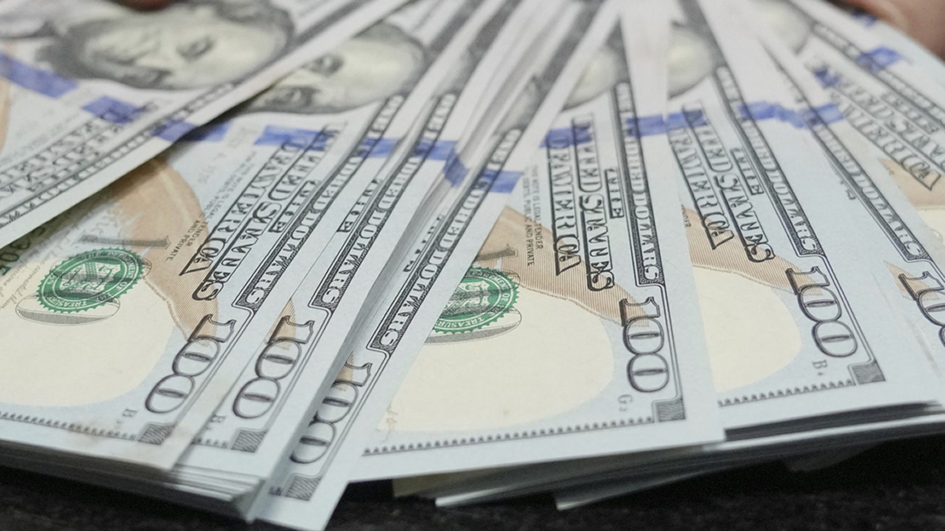 Hundradollarssedlar utspridda i ett fläktmönster