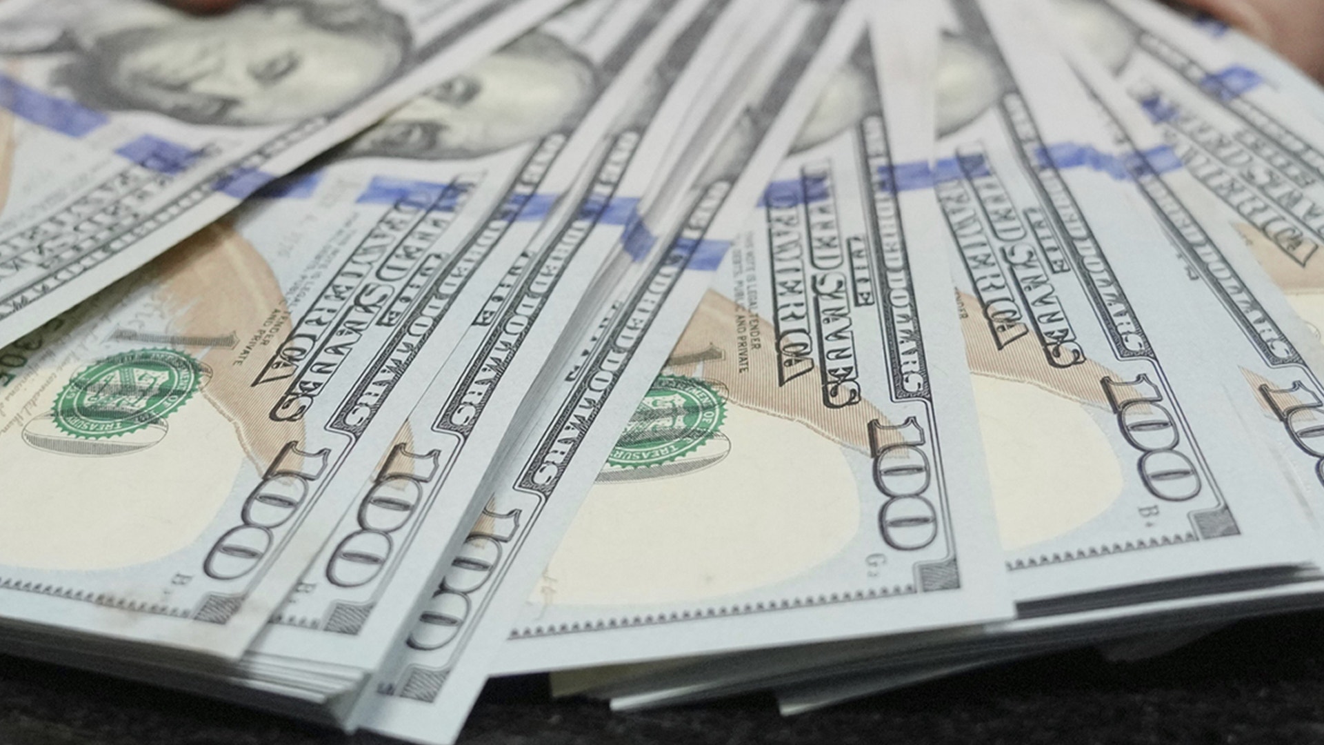 Hundradollarssedlar utspridda i ett fläktmönster