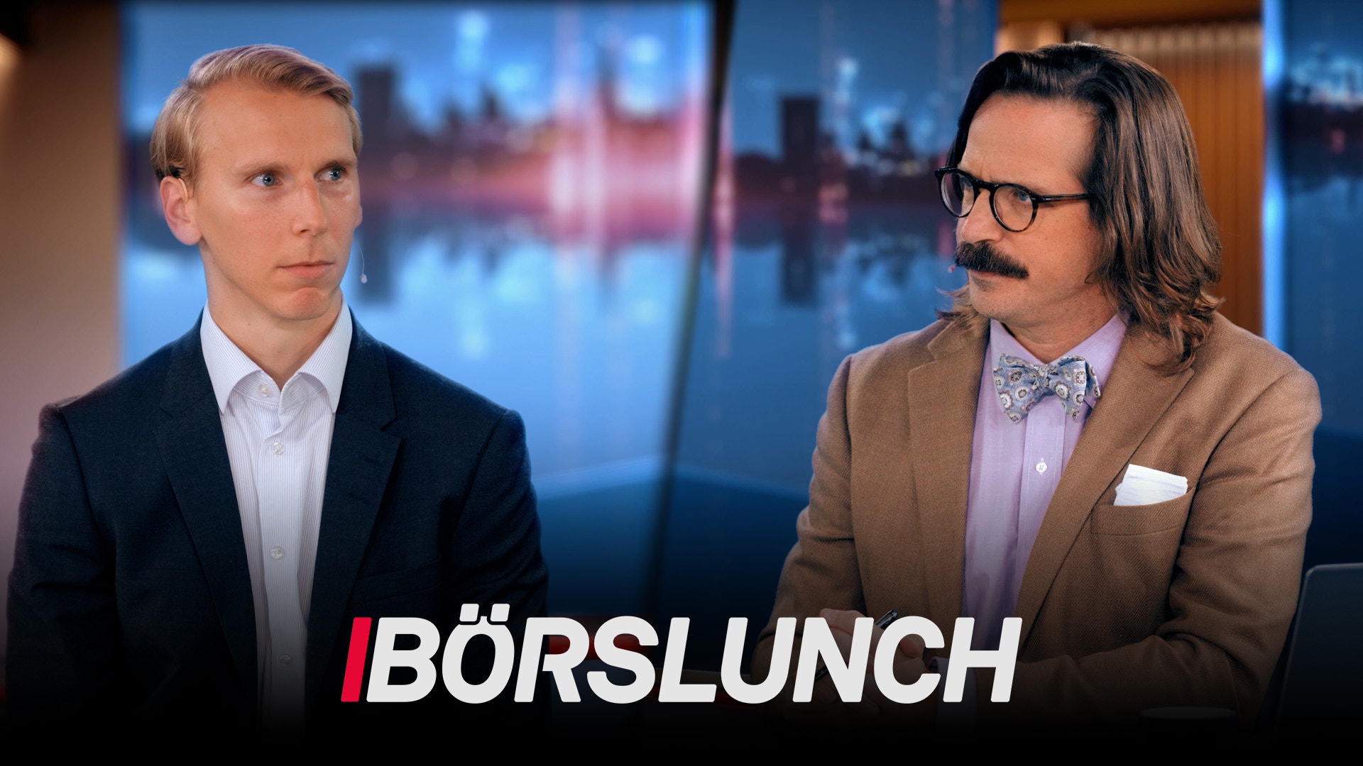 Två män i en TV-studio med stadsvy i bakgrunden. Programtitel Börslunch visas längst ned på skärmen.