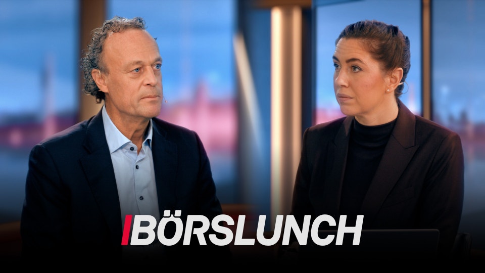 En man och en kvinna i affärskläder sitter mitt emot varandra i en studiomiljö med en stadshorisont i bakgrunden. Mannen bär en mörk blazer och ljusblå skjorta, kvinnan bär en svart blazer. De verkar diskutera något allvarligt. Texten "BÖRSLUNCH" visas längst ned på bilden.