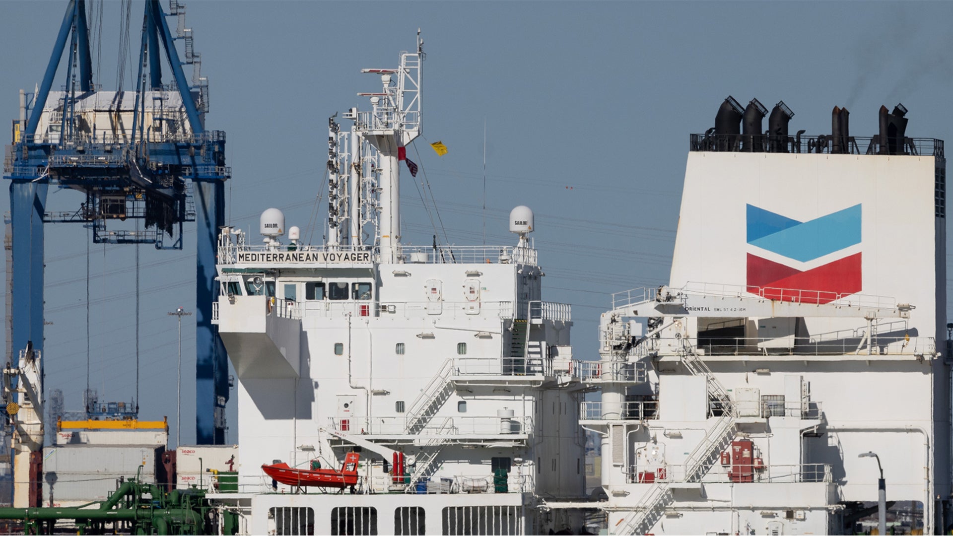 Oljetankfartyg dockat vid hamn med lastningsanordningar