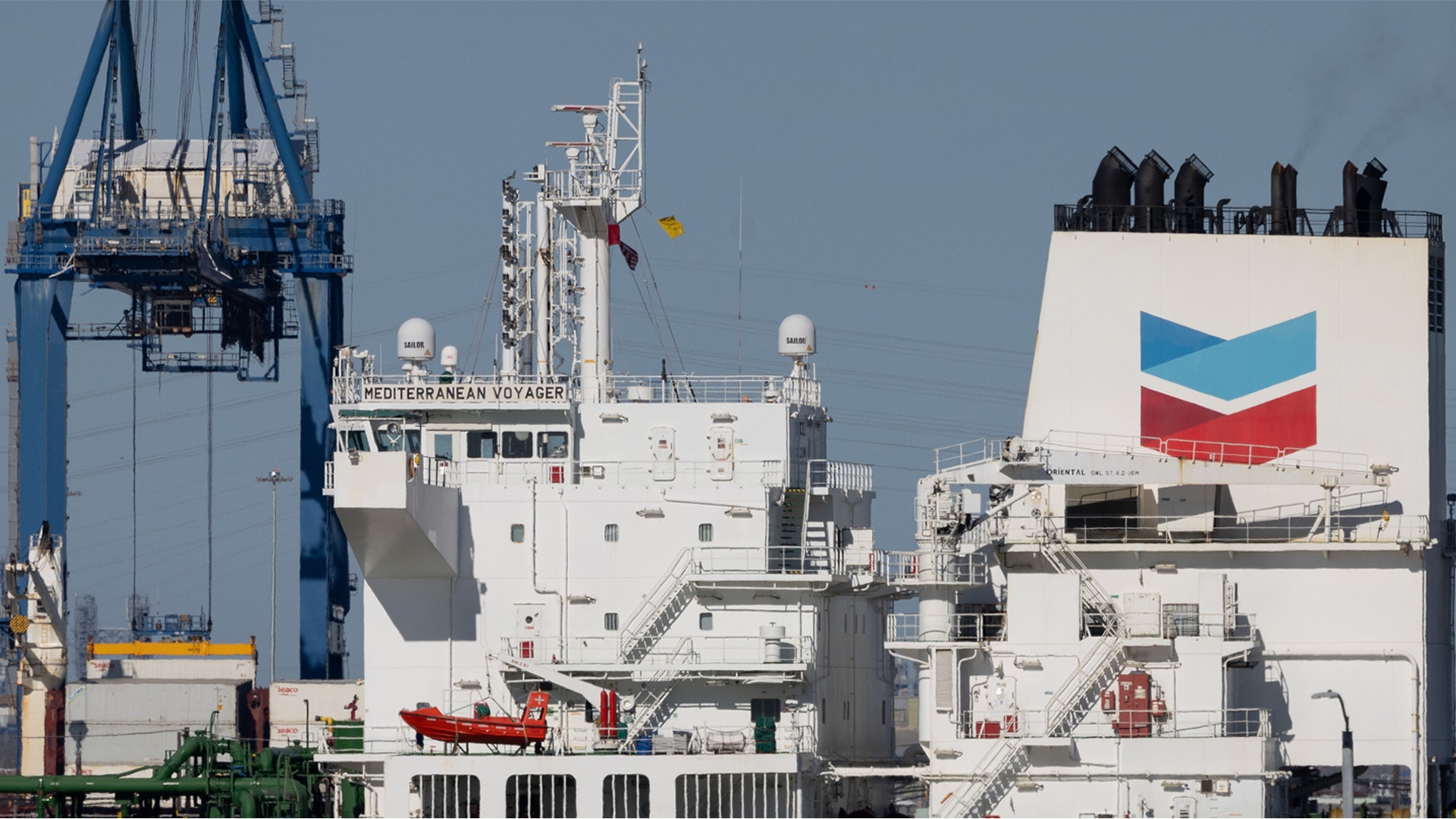 Oljetankfartyg dockat vid hamn med lastningsanordningar