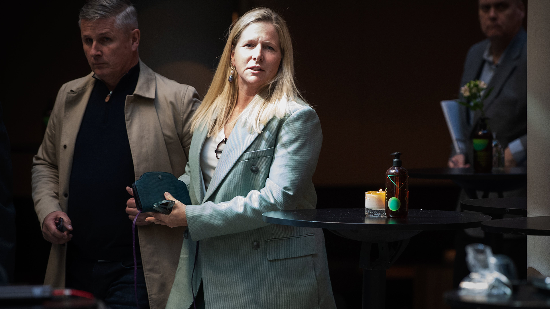 Kvinna i grå kavaj presenterar vid ett möte eller seminar