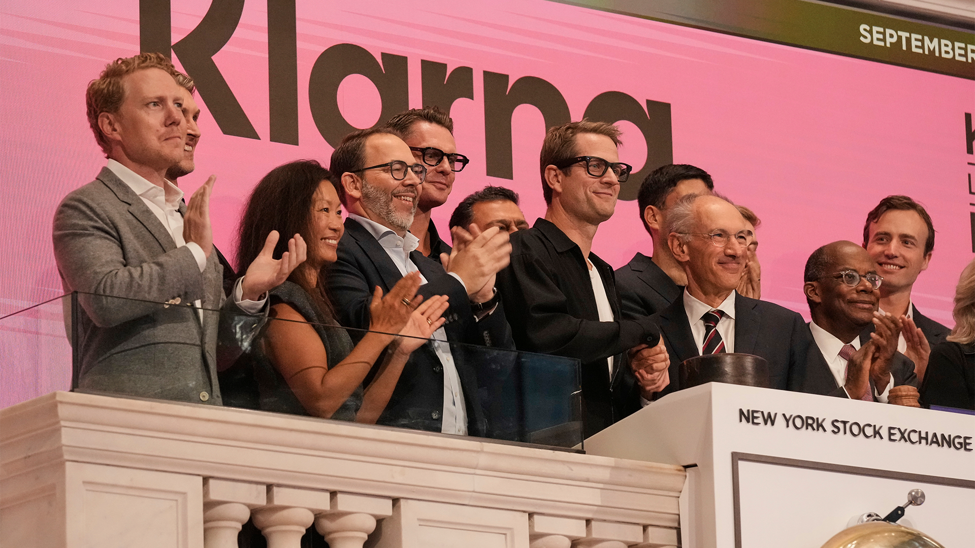 En grupp personer applåderar på en balkong på New York-börsen i samband med Klarnas börsnotering.