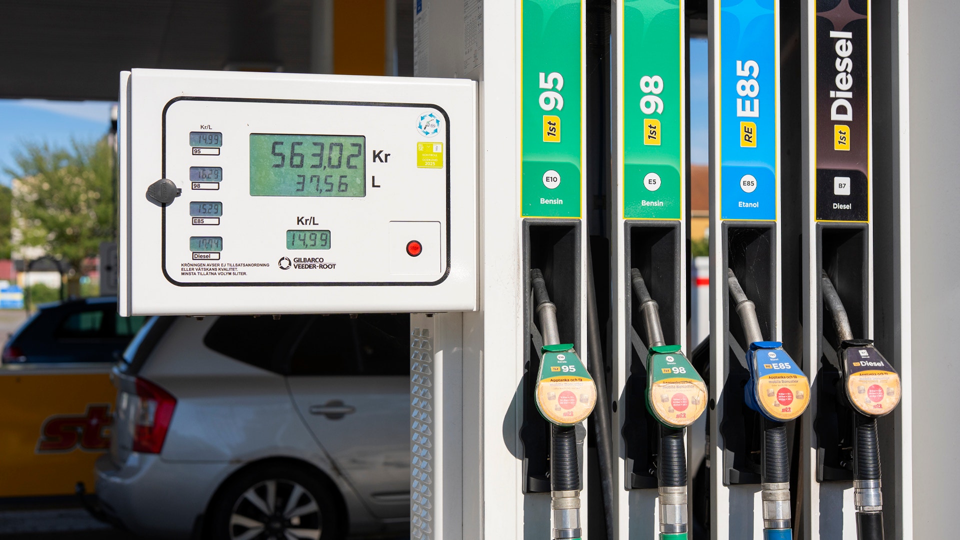 En bensinpump vid en bensinstation med digital display som visar pumpkostnad. Fyra bränslepumpar är synliga: 95, 98, E85 och Diesel.