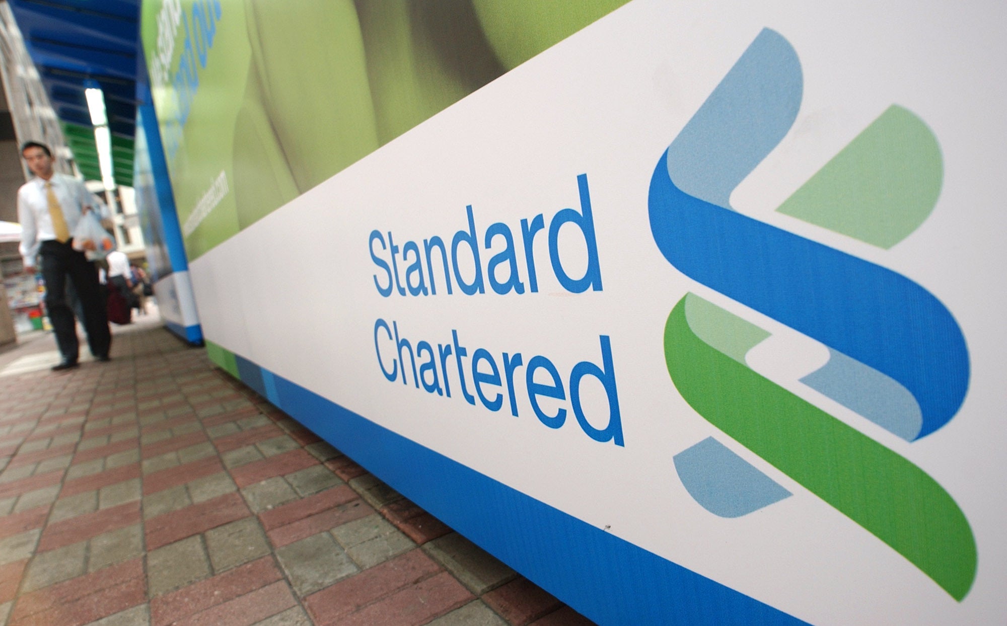 Standard Chartered logotyp på en vit skylt med blå och grön design