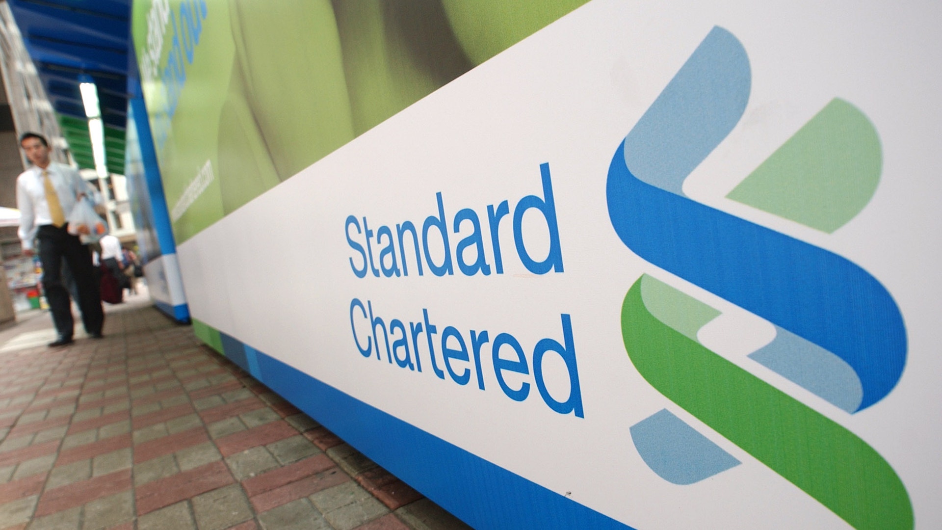 Standard Chartered logotyp på en vit skylt med blå och grön design