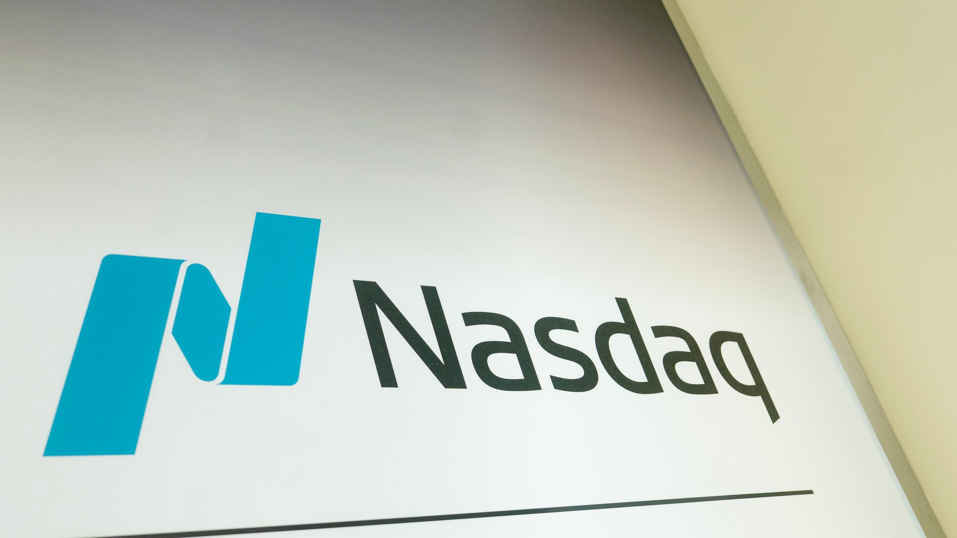 Nasdaq-logotypen med blå symbol och svart text på vit bakgrund