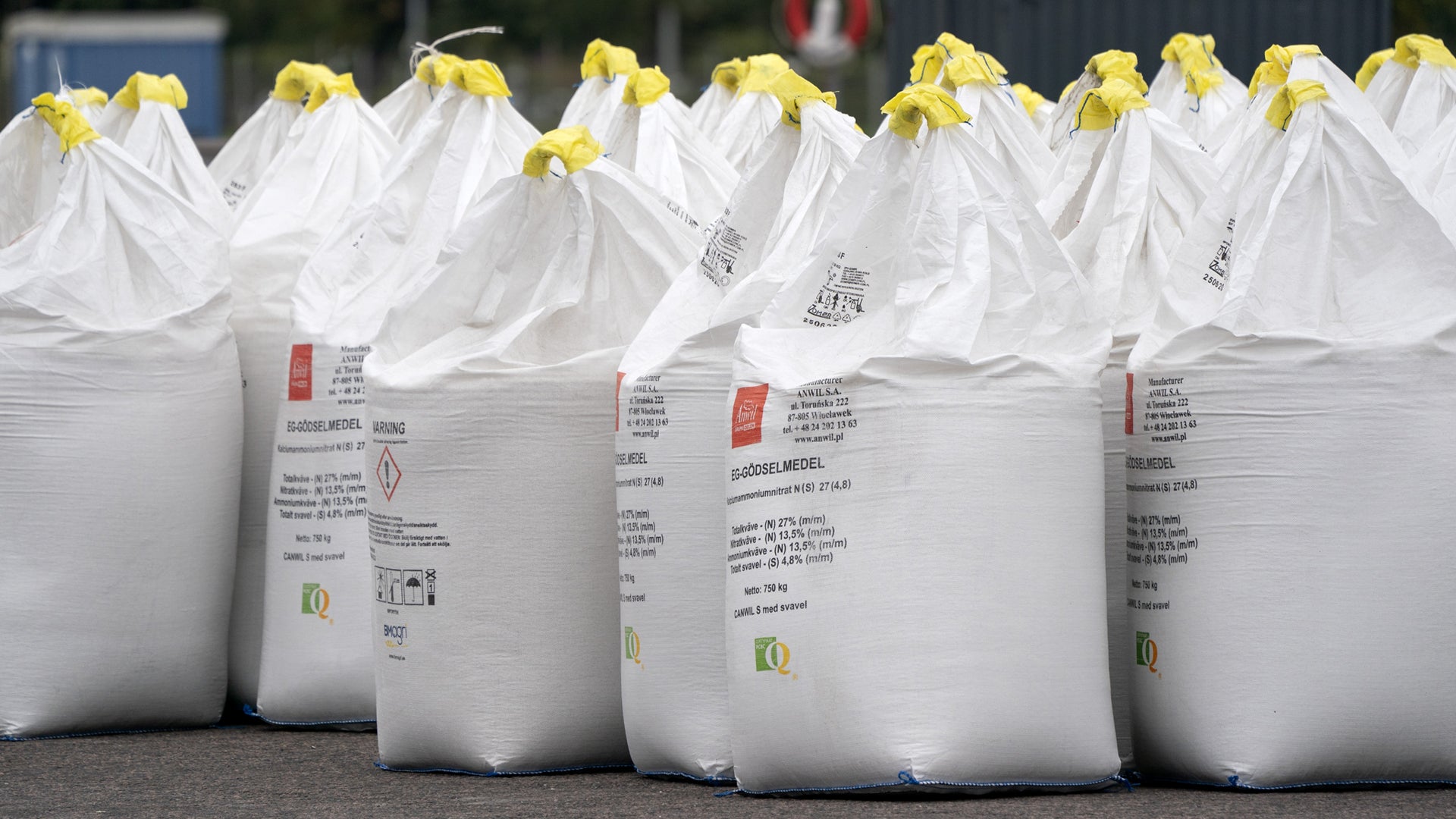Rad av vita bulksäckar med gula snören ordnade på rad