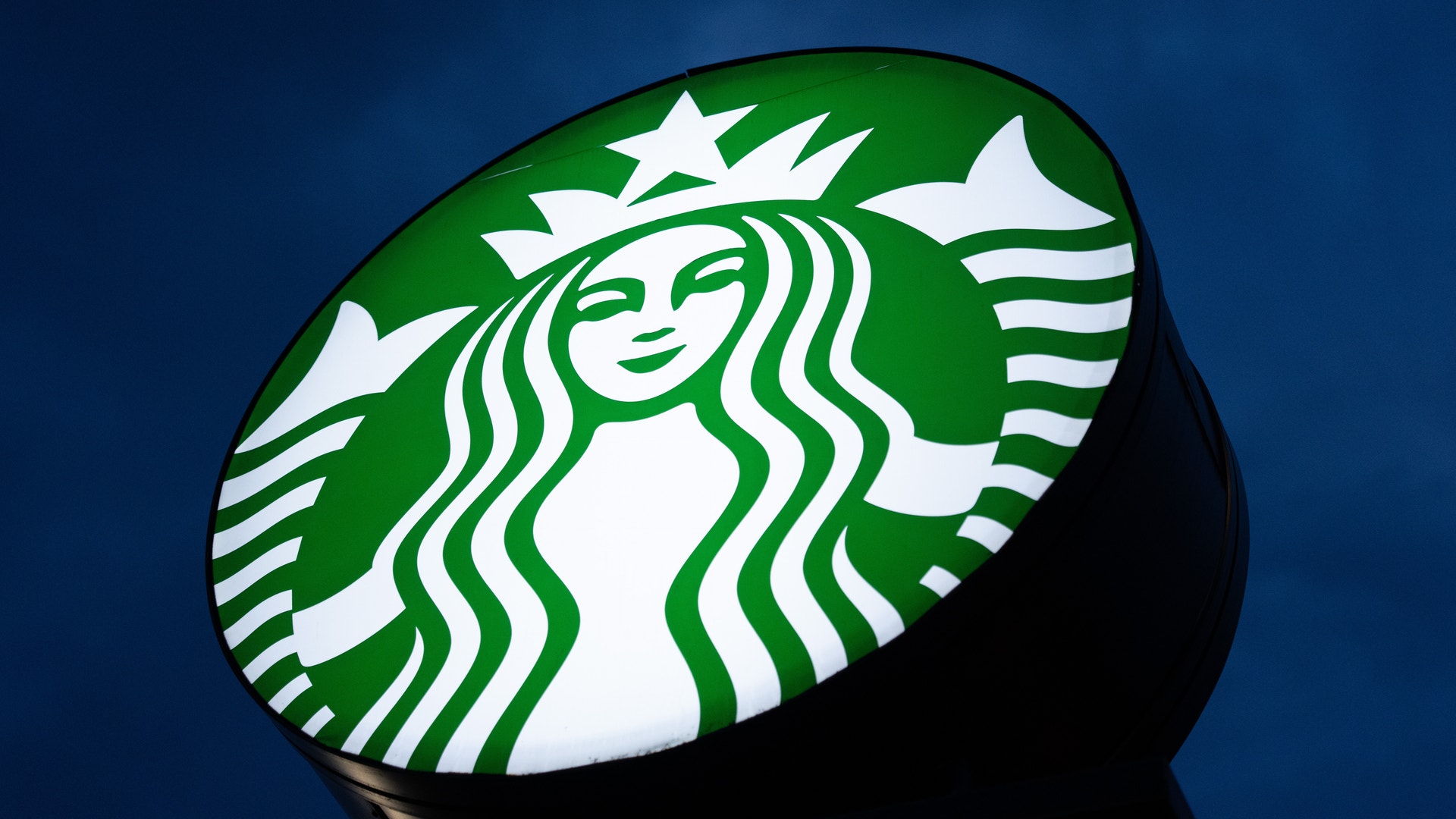 Starbucks logotyp med en grön och vit siren på blå bakgrund