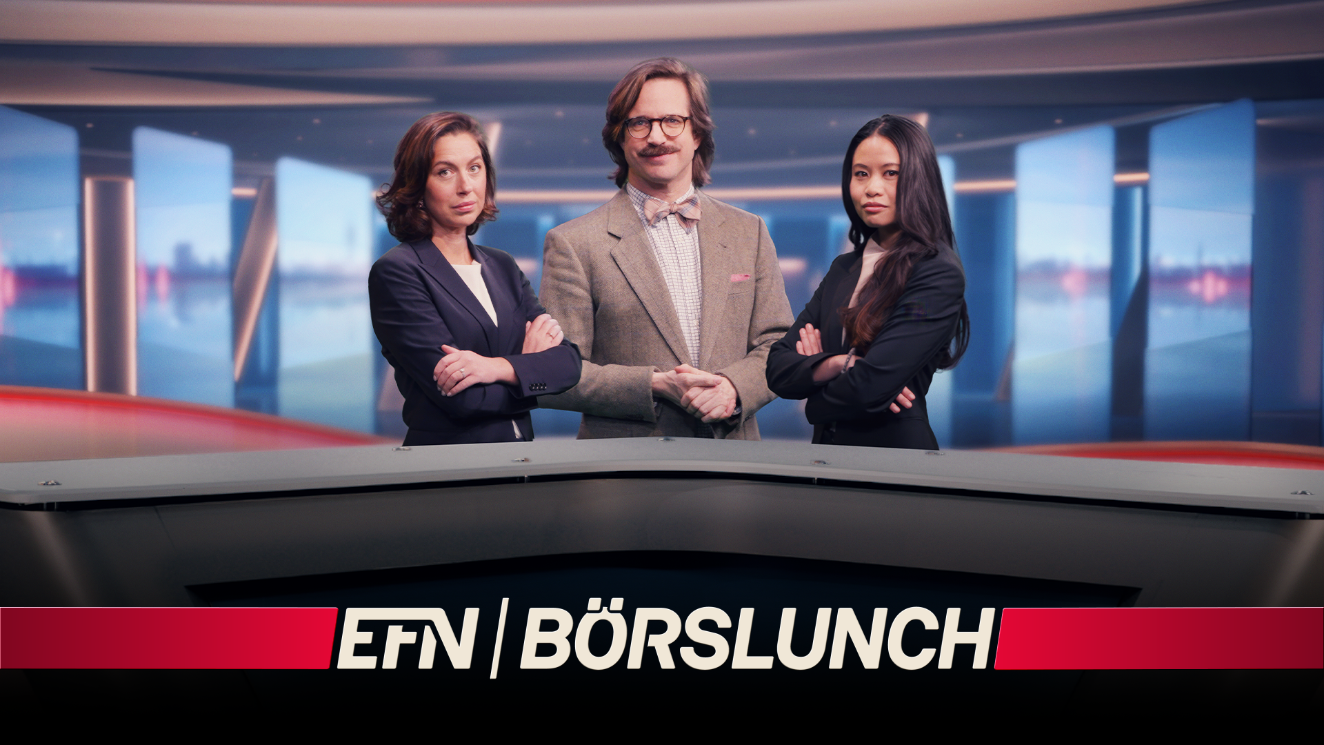 Tre professionella presentatörer vid ett nyhetsbord med stadsvy i bakgrunden för programmet EFN Börslunch
