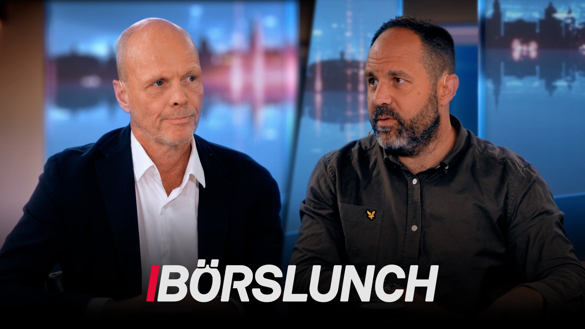 Två män sitter och diskuterar framför en stadsskyline. Texten Börslunch visas längst ned på bilden.