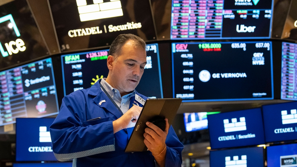 En handlare på Wall Street framför skärmar.