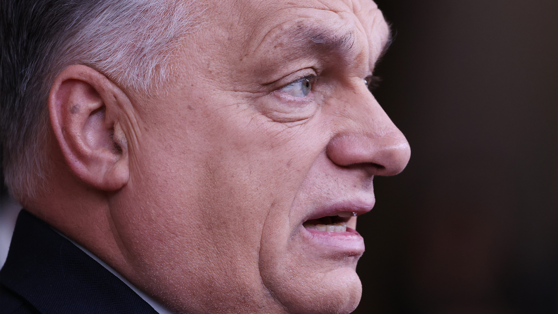 Profilbild av en äldre man med grått hår mot mörk bakgrund