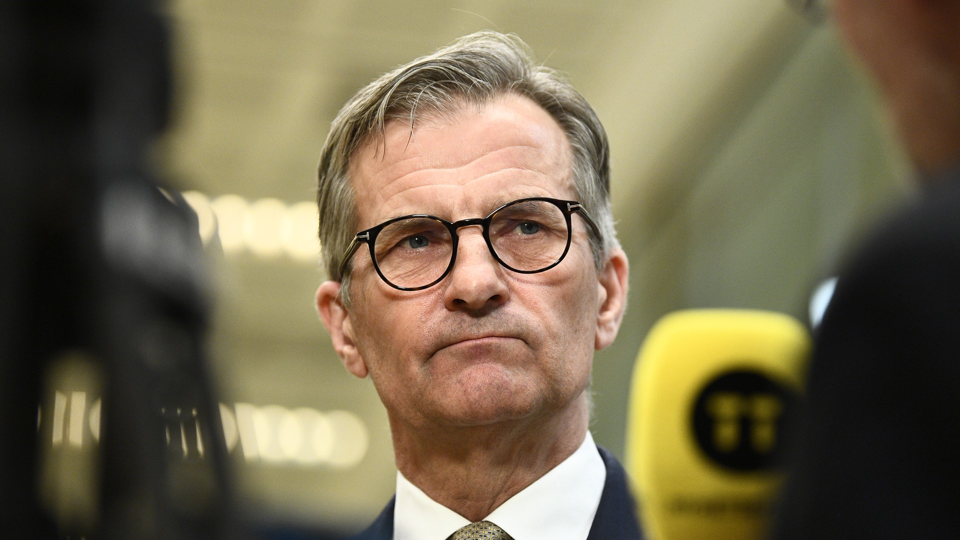 Porträtt av en man i glasögon och formell affärsklädsel