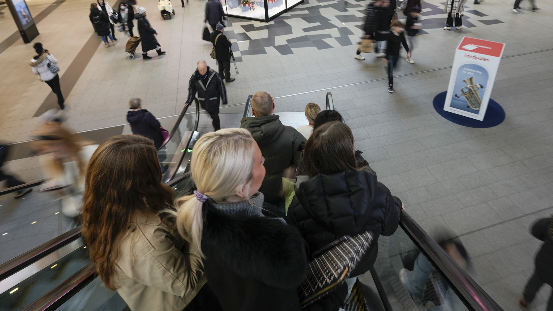 Människor på en rulltrappa i ett offentligt utrymme