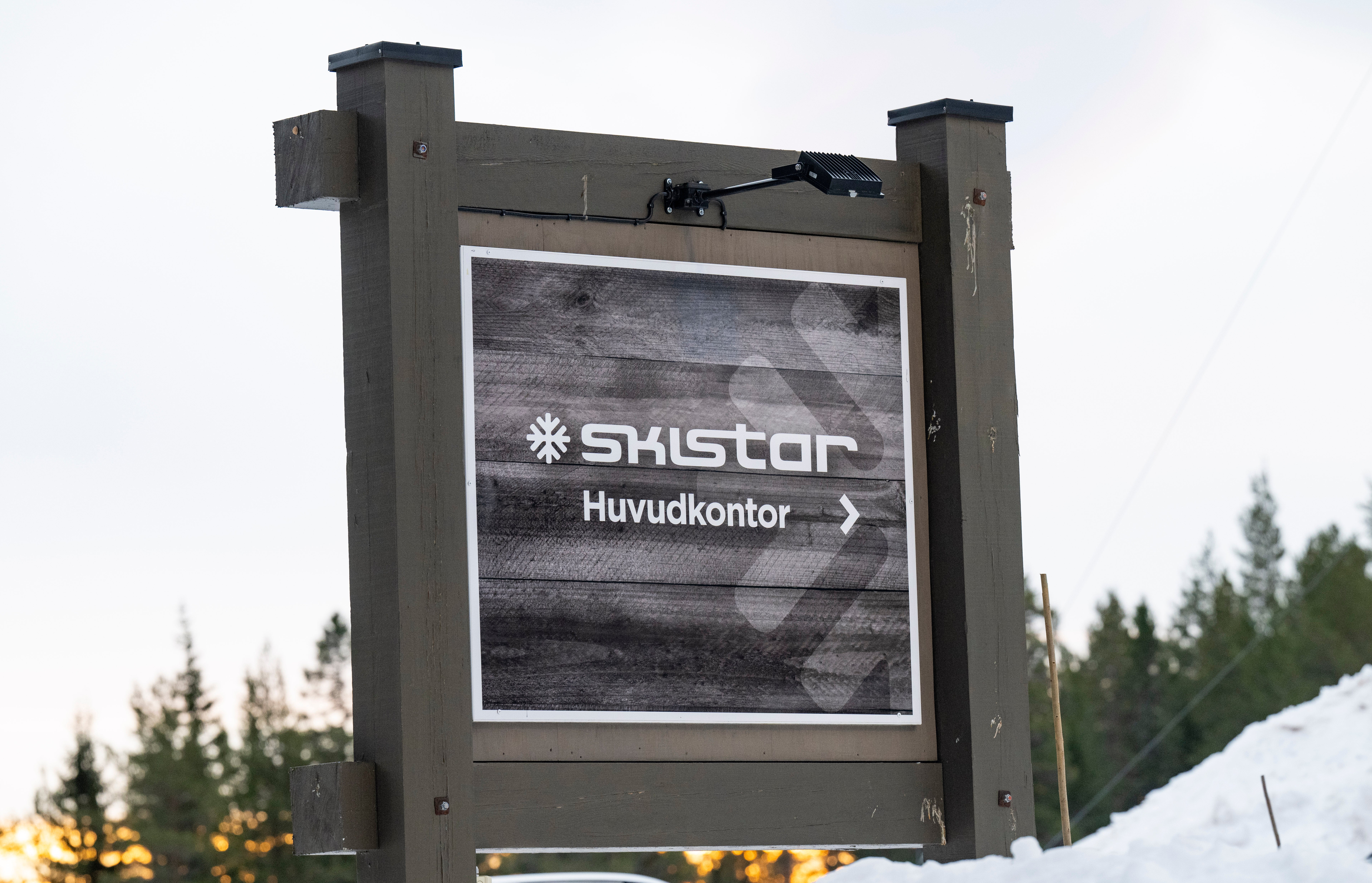 En skylt med texten "Skistar Huvudkontor" och en pil, omgiven av snö och skog.
