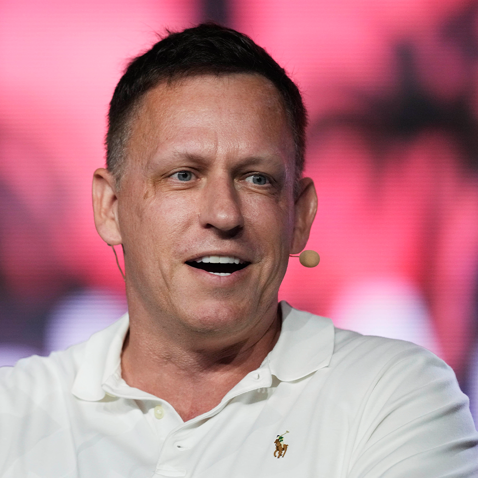 En man med kort mörkt hår viftar med en hundra dollars-sedel