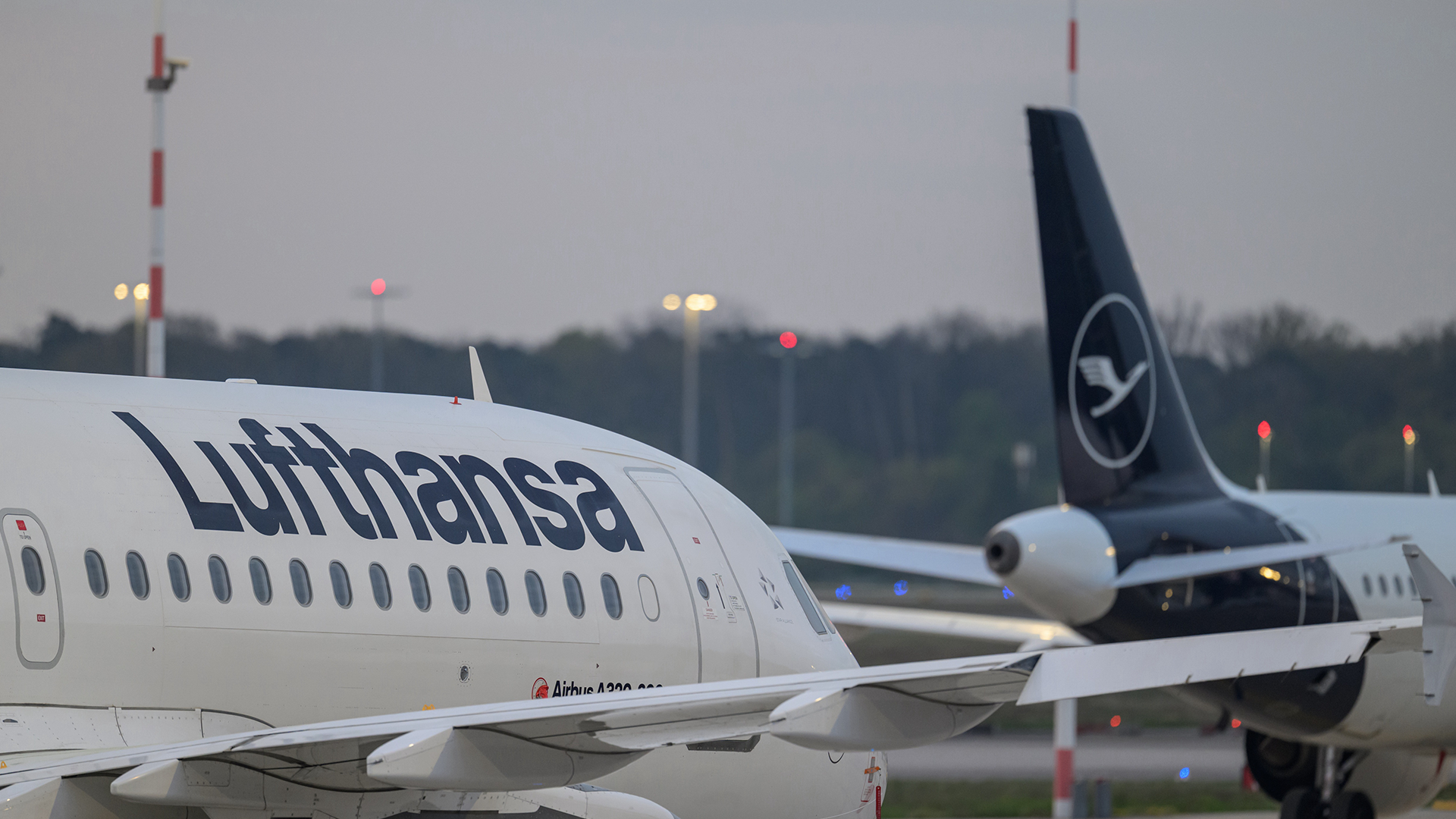 Två flygplan från Lufthansa rör sig på en flygplats.