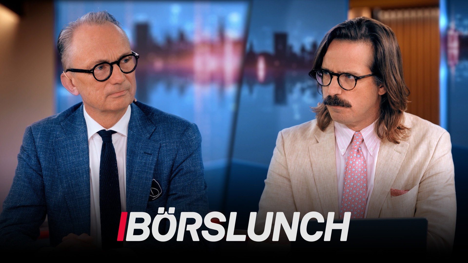 Två män i kostym sitter vid ett skrivbord framför en stadshorisont. Texten Börslunch visas längst ner på bilden.