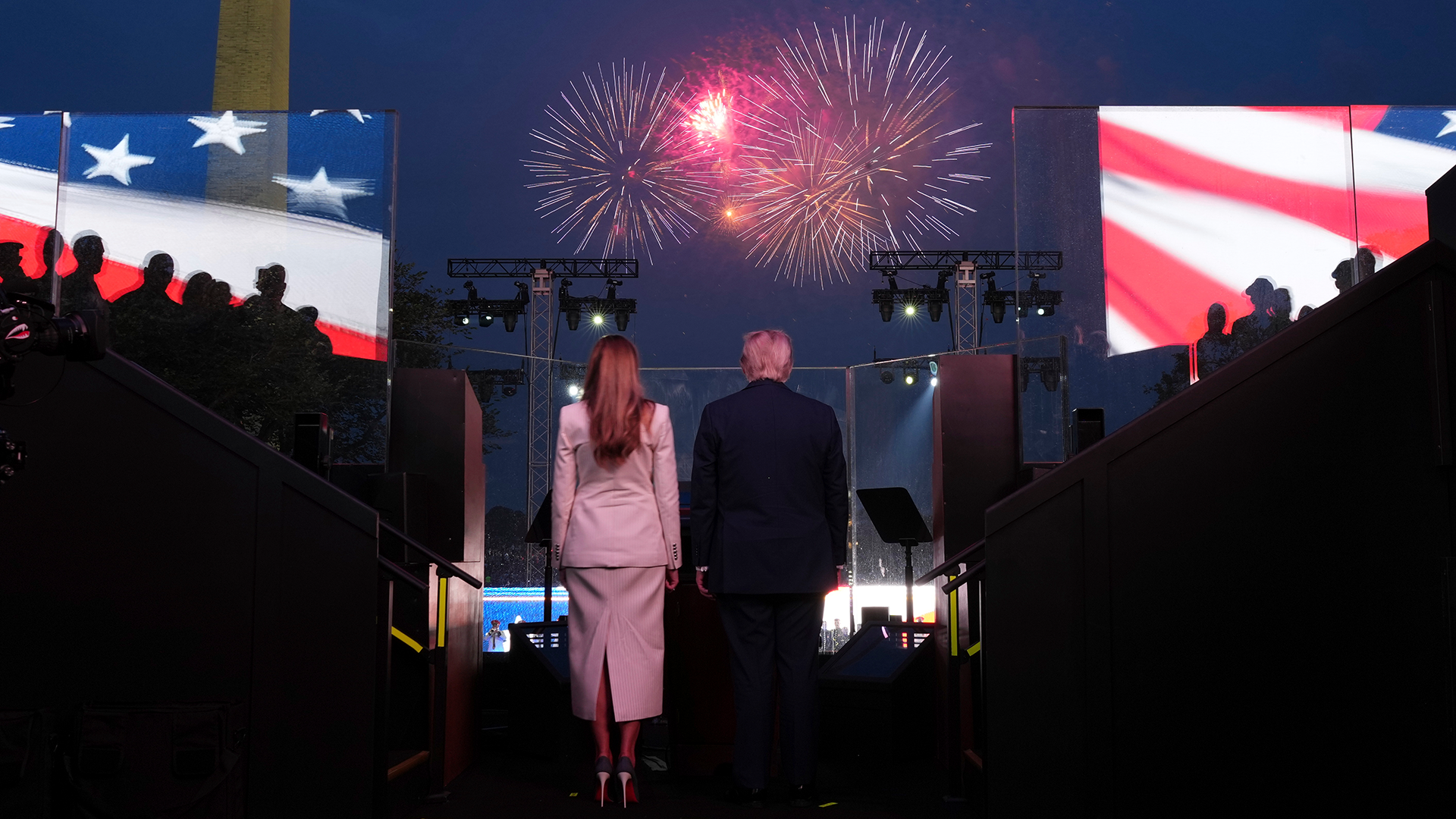 Donald Trump och Melania Trump på årets firande av USAs nationaldag, vände mot fyrverkerierna som pryder himlen i röd kulör.